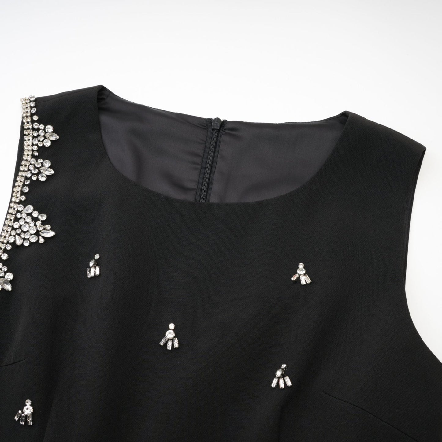 Black dress featuring accentuating contrast colors sleeveless design classy round neck unique cutout design sparkling crystal embellishments rear zip fastening stylish thigh length Made of 100% Polyester