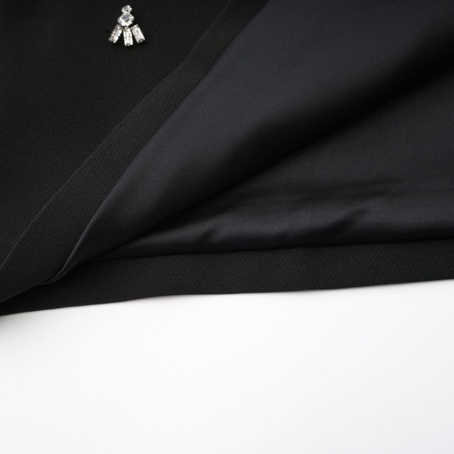 Black dress with accentuating contrast colors sleeveless design classy round neck unique cutout design sparkling crystal embellishments rear zip fastening stylish thigh length 100% Polyester composition