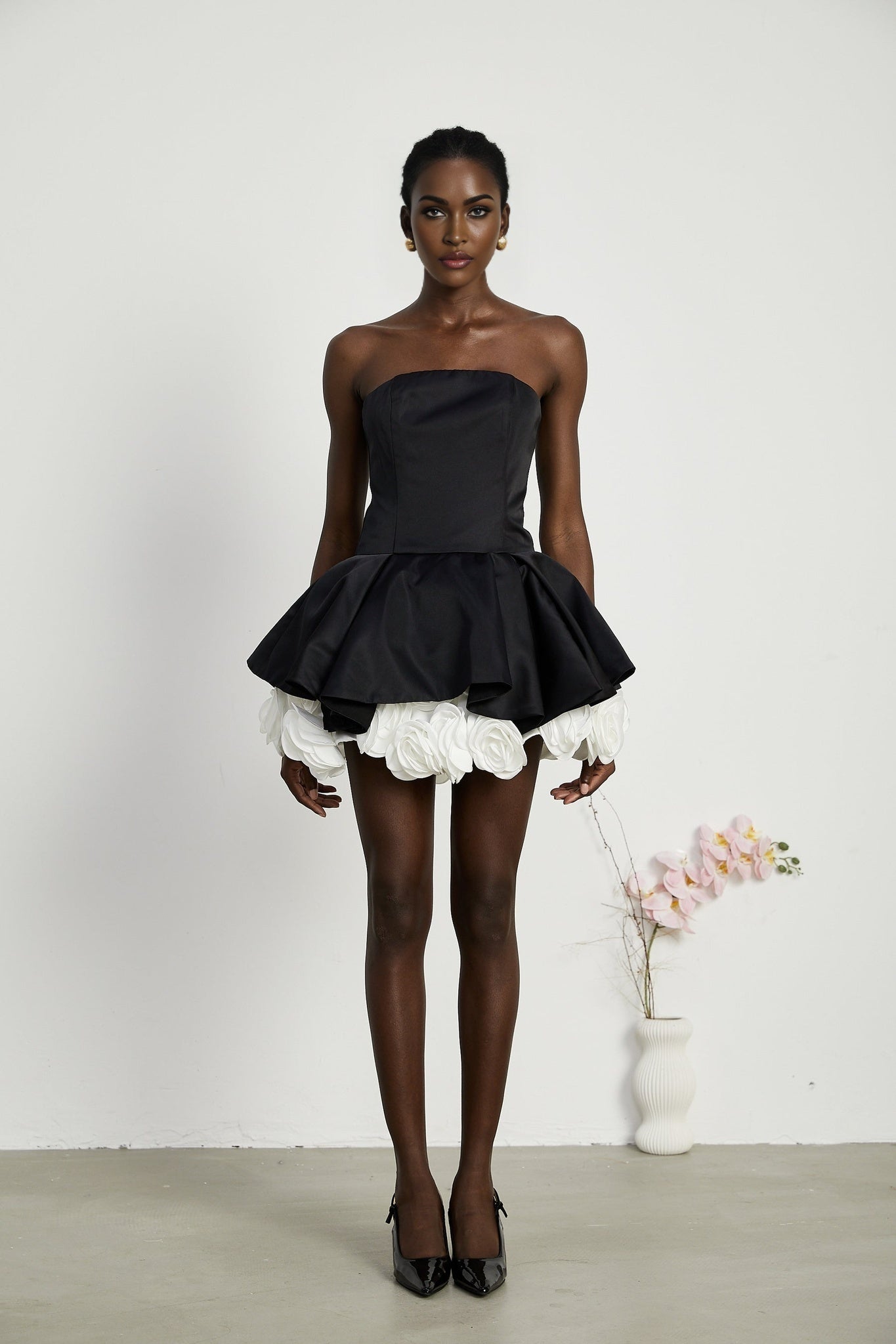 Black strapless mini dress with corset style and petal details named Lucie