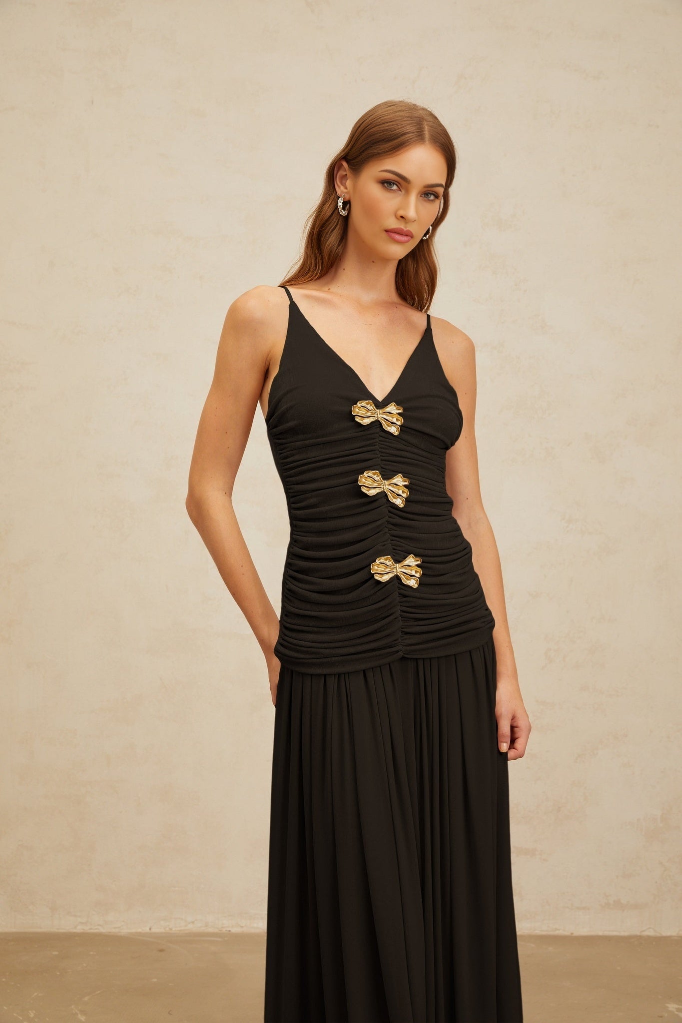 Black V-neck sleeveless top with brooch and ruched detailing and adjustable spaghetti straps, paired with pleated maxi skirt in 100% Terylene fiber