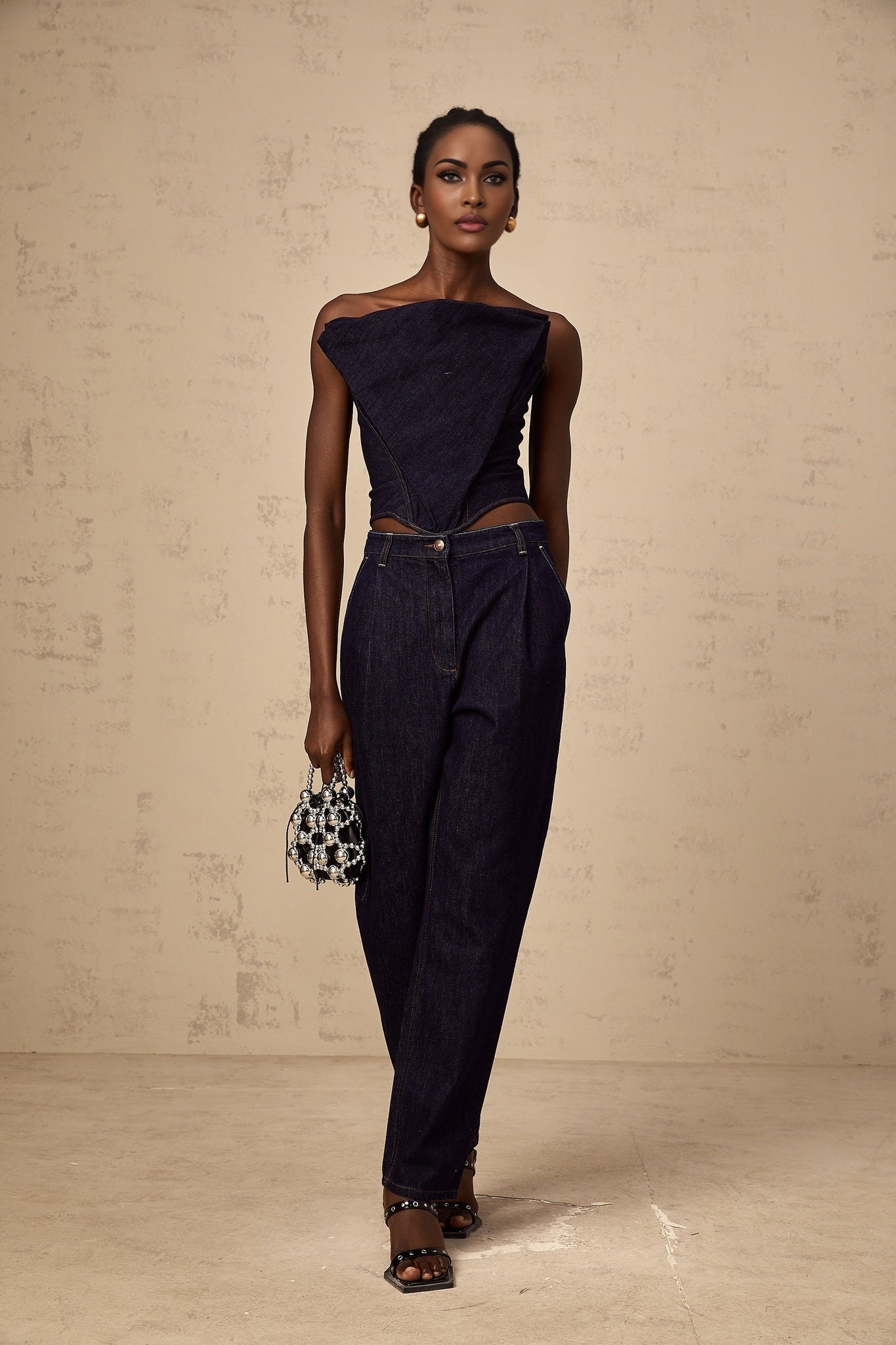 Blue high rise jeans with pleated details on a white background