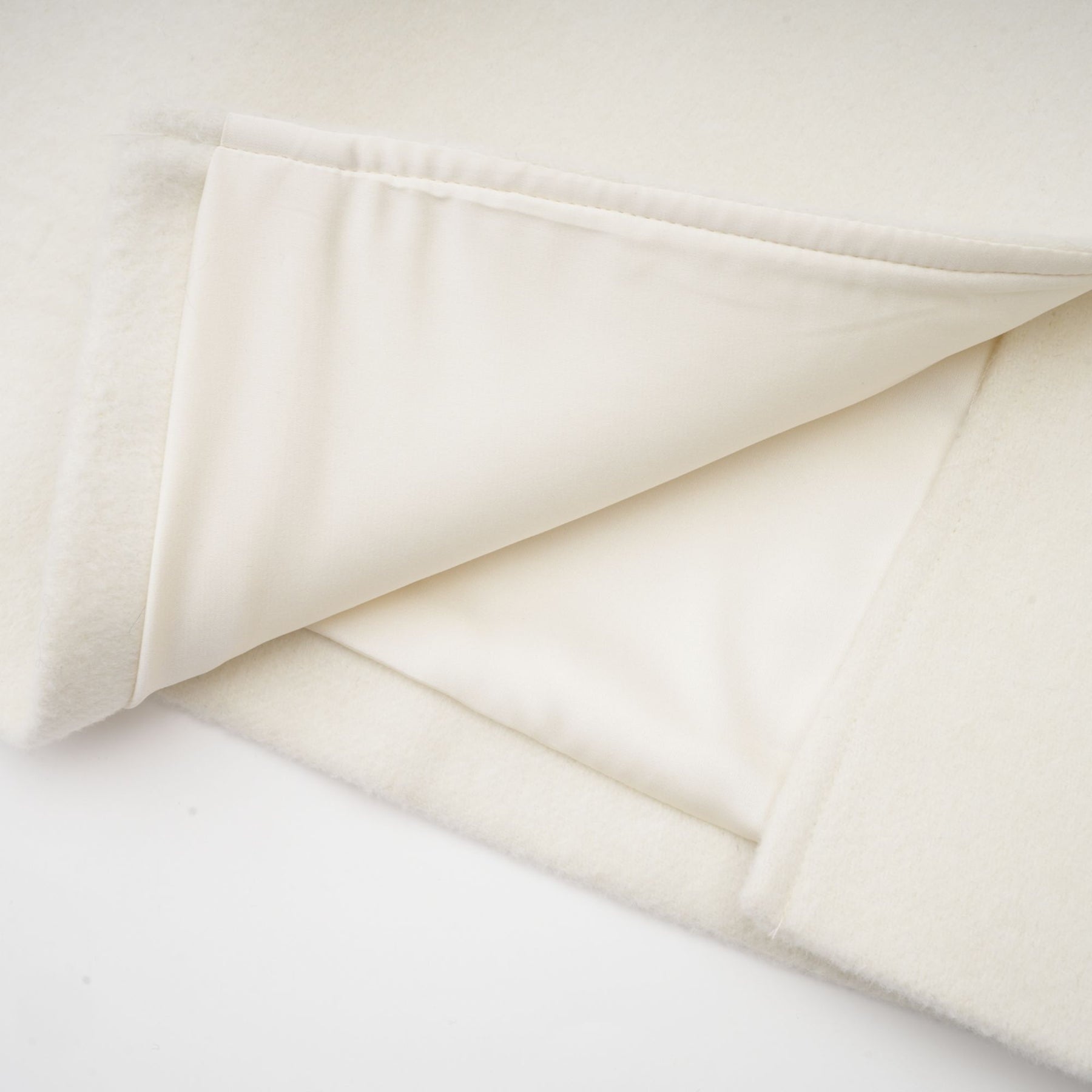 Elegant white jacket with cape design featuring intricate embellishments and beadwork on shoulders and sleeves