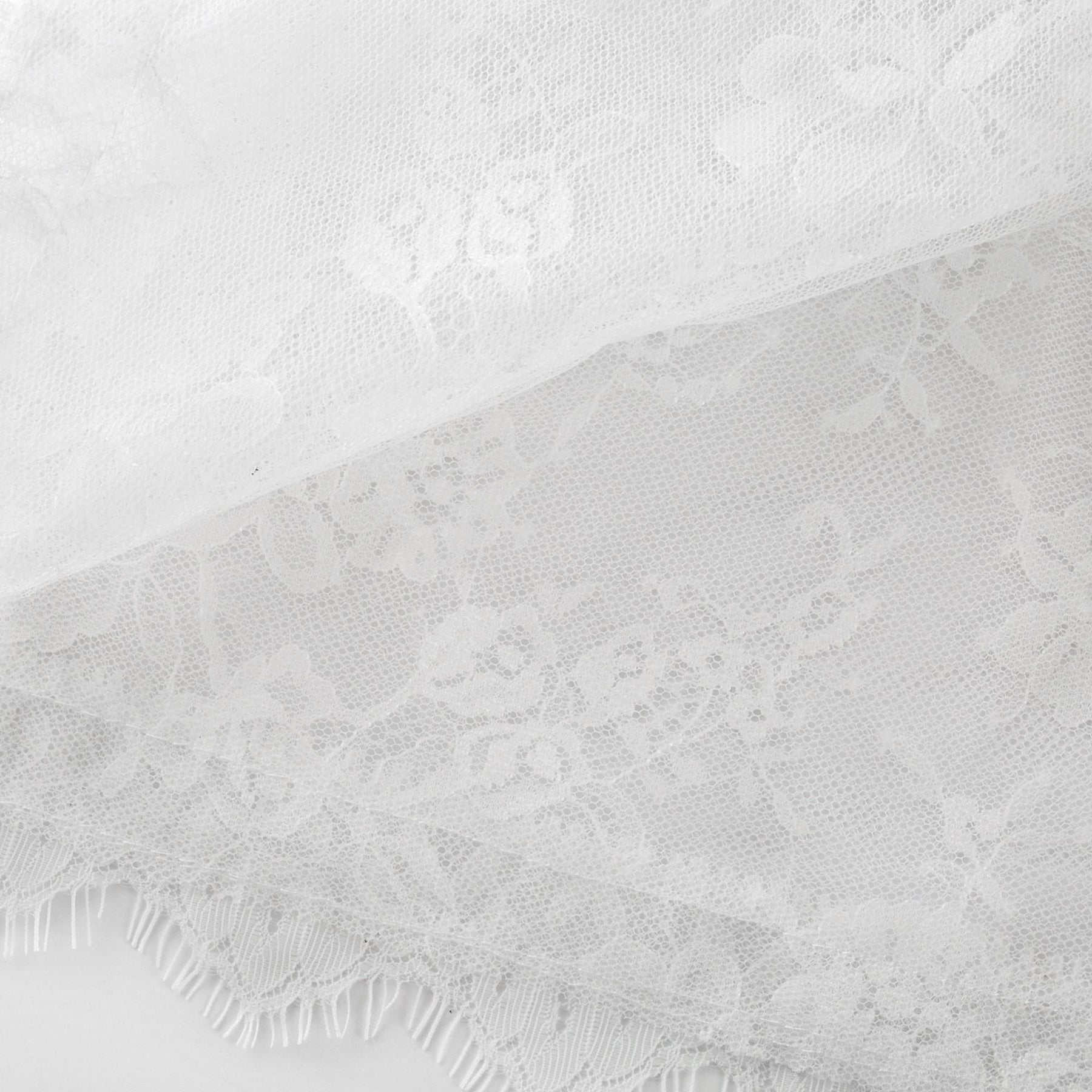 Elegant white lace midi dress with tiered layers by Melisande