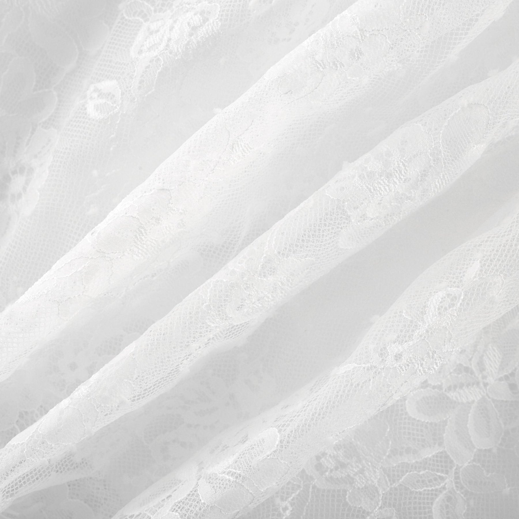 Elegantes gestuftes Midikleid aus weisser Spitze mit femininem Muster und leichtem fliessenden Schnitt