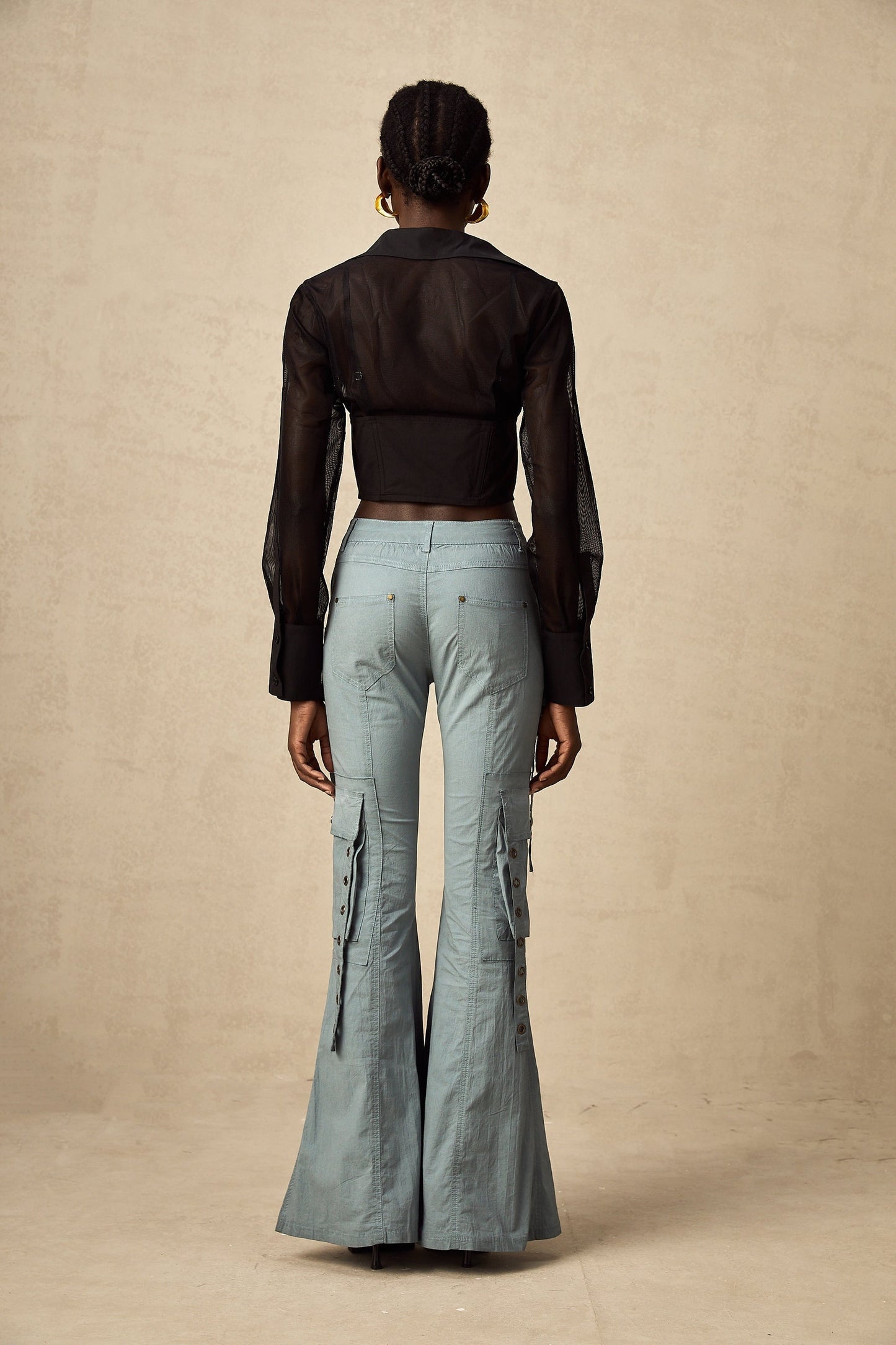 Green flared cargo trousers with belt loops and multiple pockets on the legs