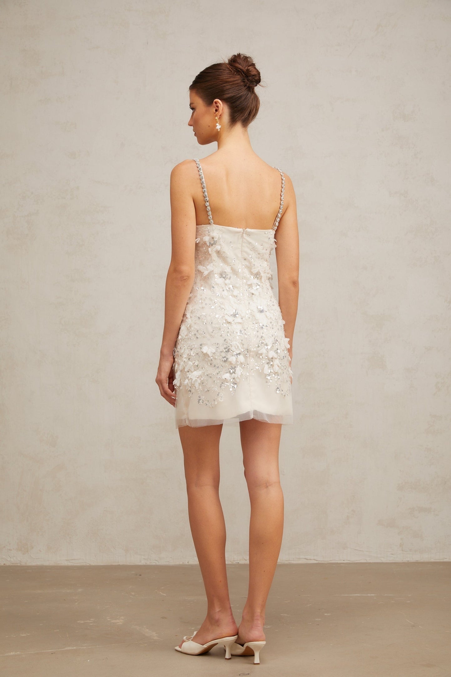 Heres a simple alt text for the product image based on the title
Young woman wearing a short sparkling dress with sequin embellishments shimmering under studio lights