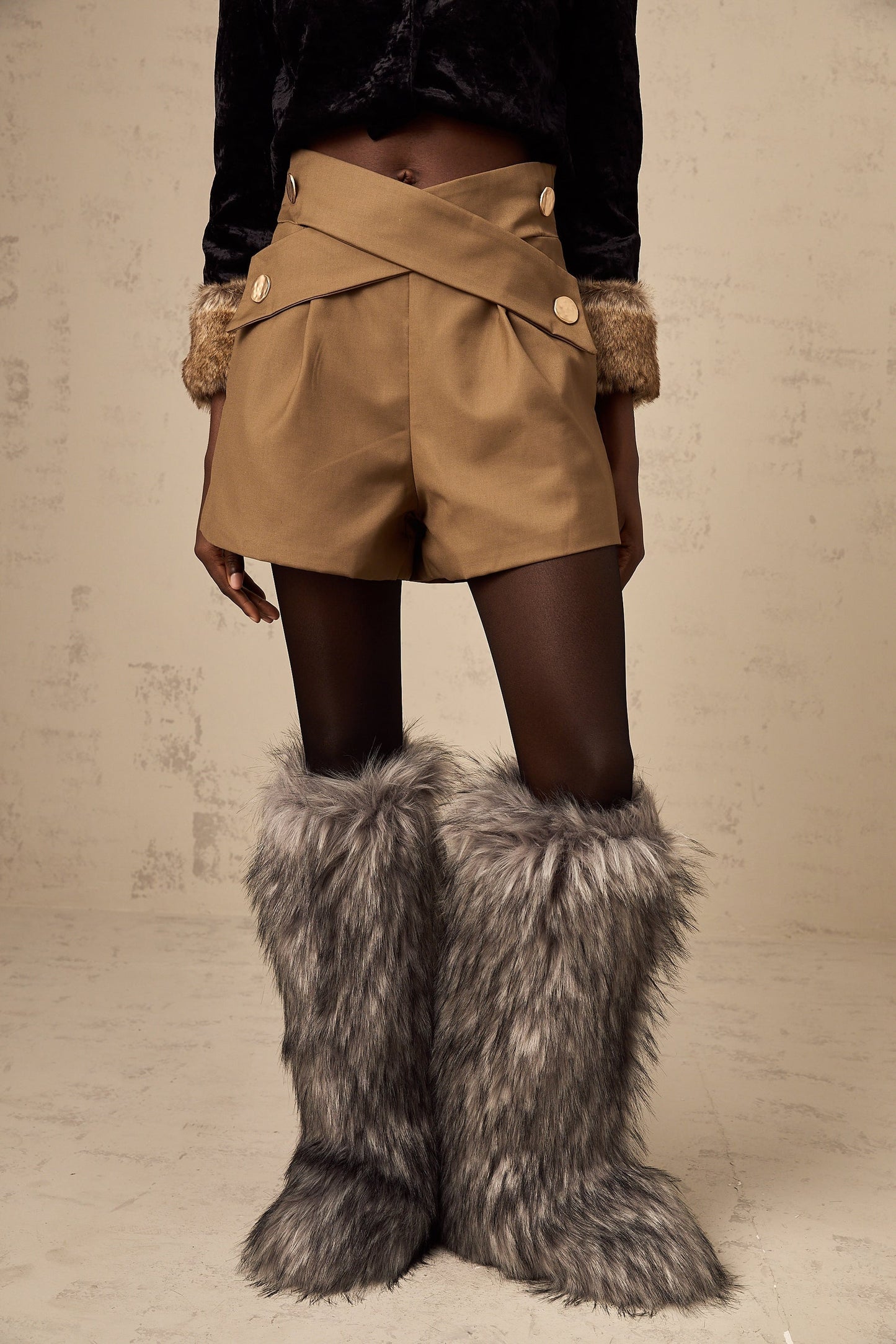 Khaki colored shorts with a crossover design at the front waistband