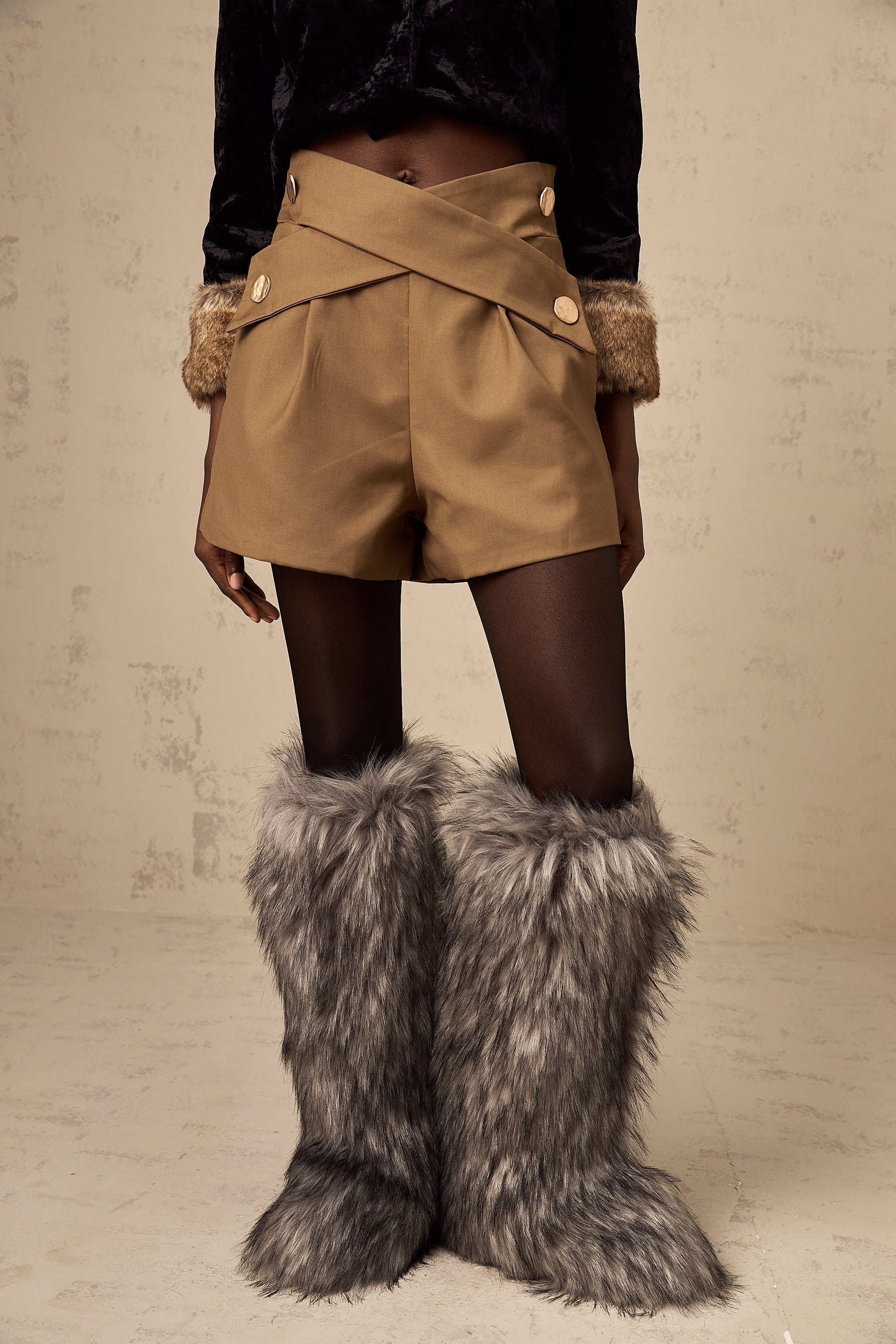 Khaki colored shorts with a crossover design at the front waistband