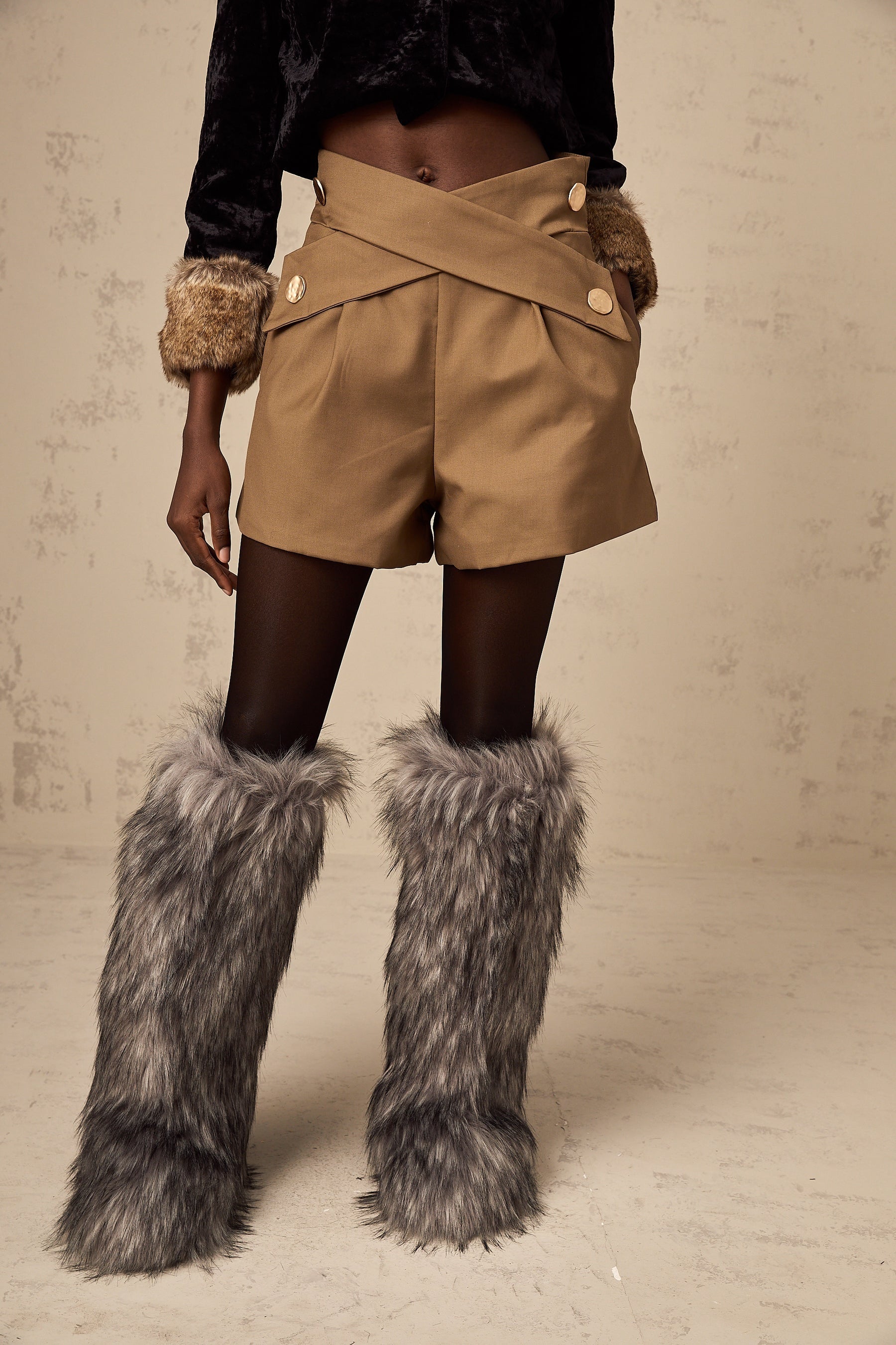 Khaki colored shorts with a crossover design at the waist featuring a loose and flowing fit