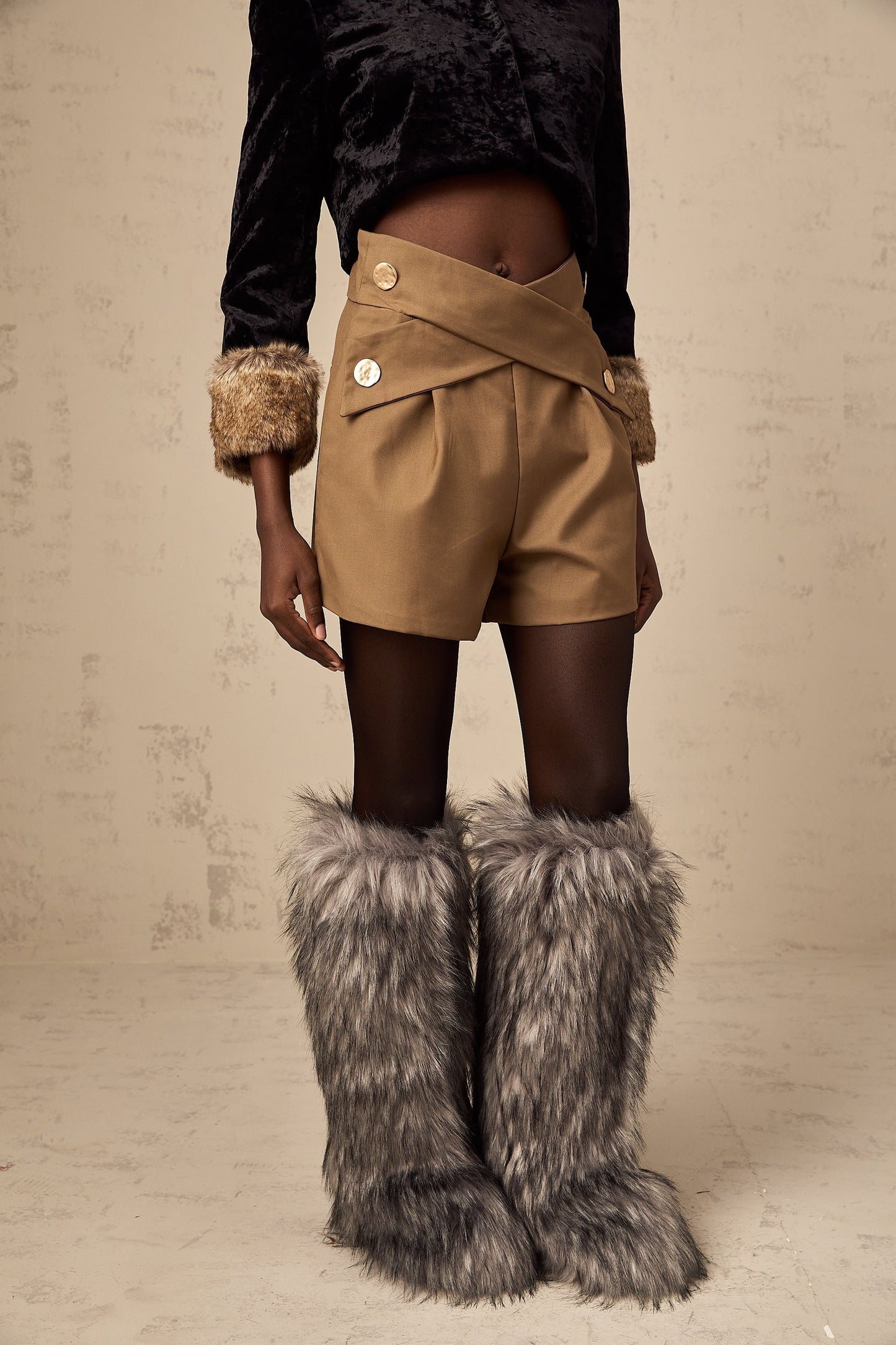 Khaki colored shorts with a crossover design at the waist featuring a loose and flowy fit