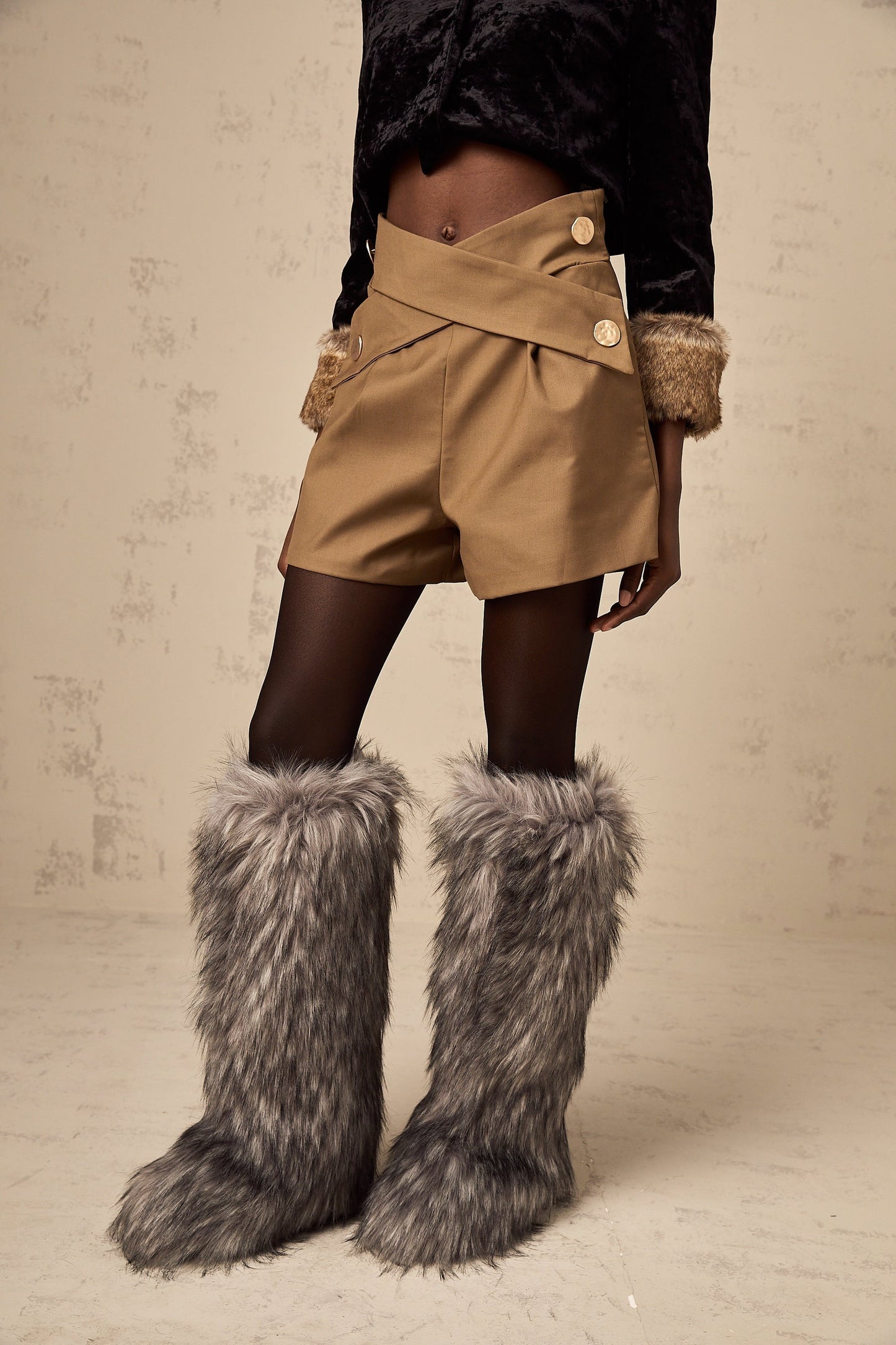 Khaki colored shorts with a crossover design at the waist featuring a loose fit and casual style