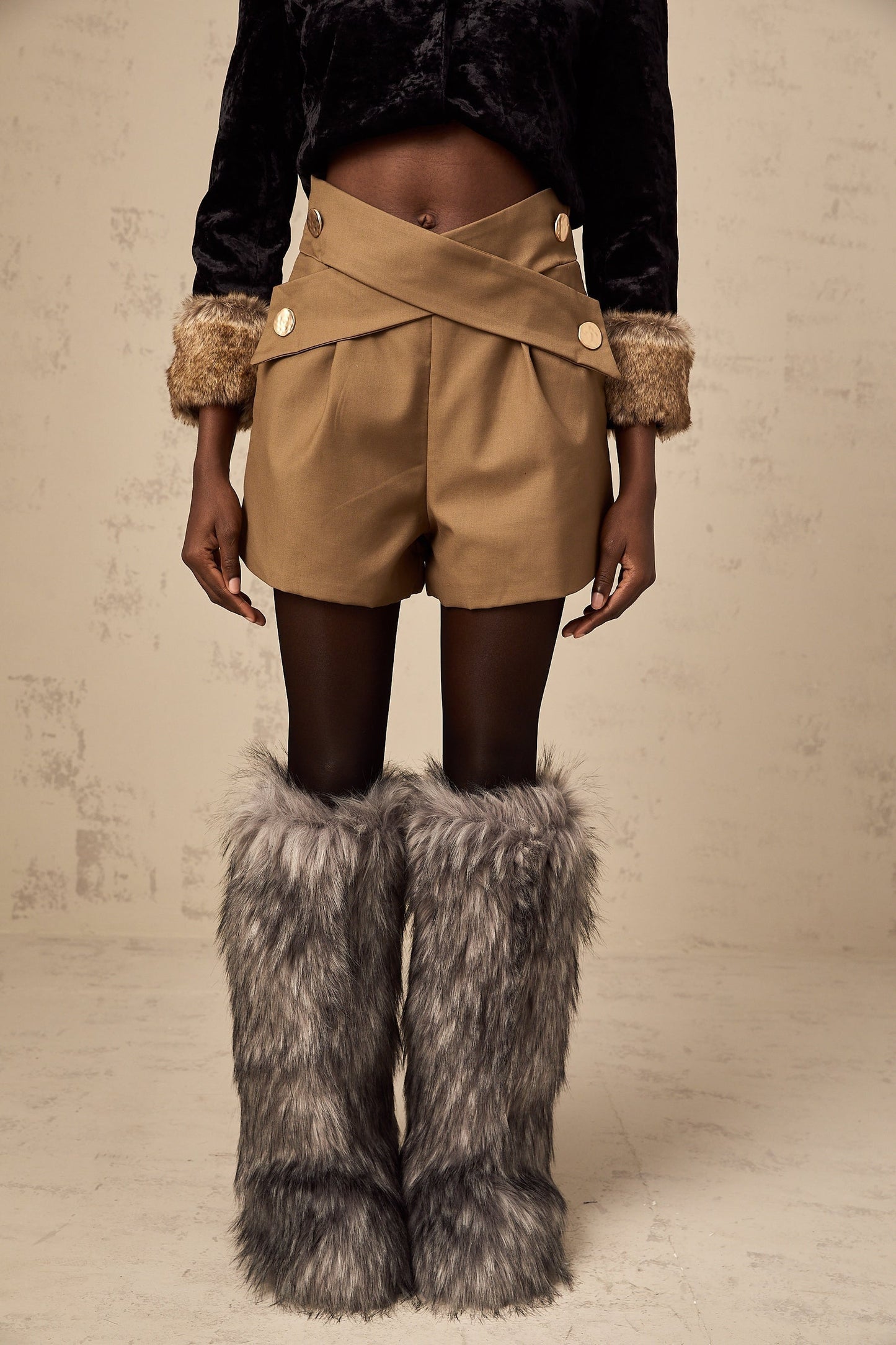 Khaki colored shorts with a crossover design detail at the waist