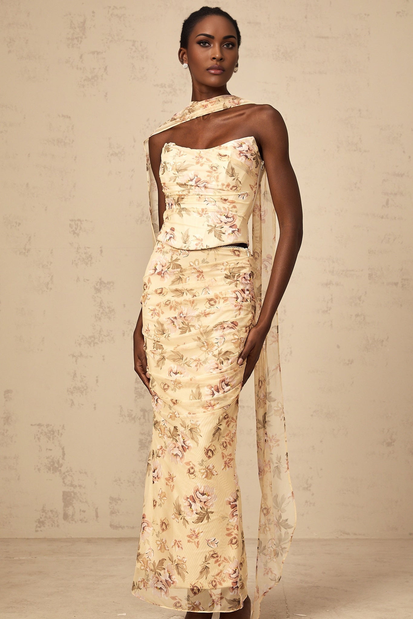 Matching yellow floral print outfit with fitted top and skirt on white background