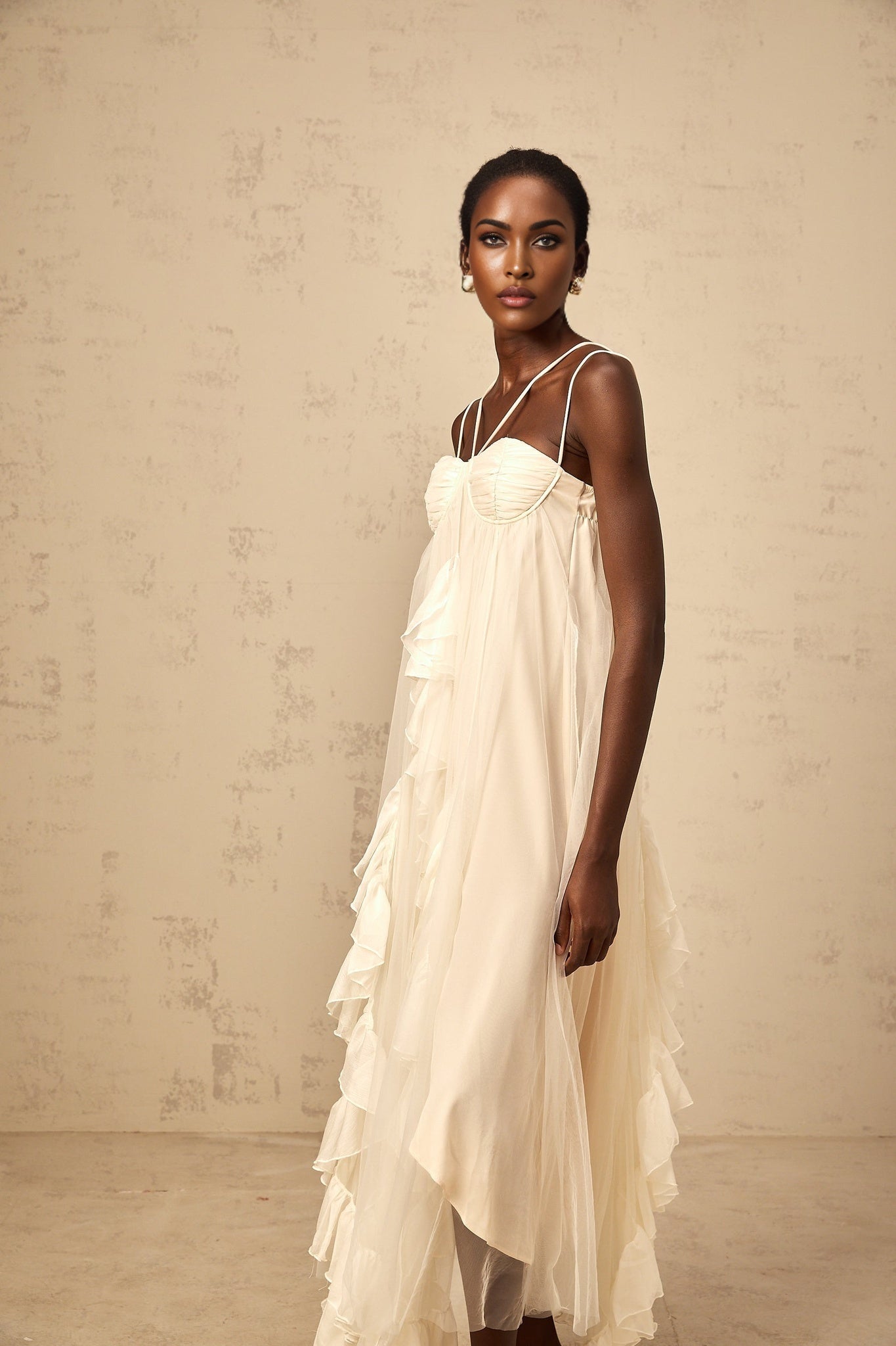 Neutral colored long maxi dress with layered ruffled tulle skirt and sleeveless bodice