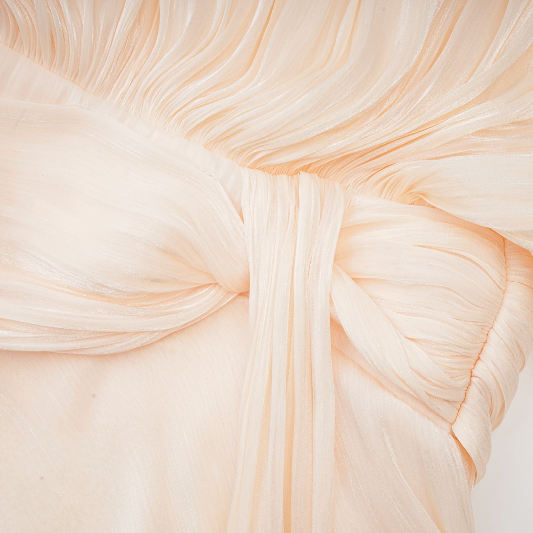 Neutral colored short dress with full pleated skirt and ruffled details featuring a mini length and feminine silhouette