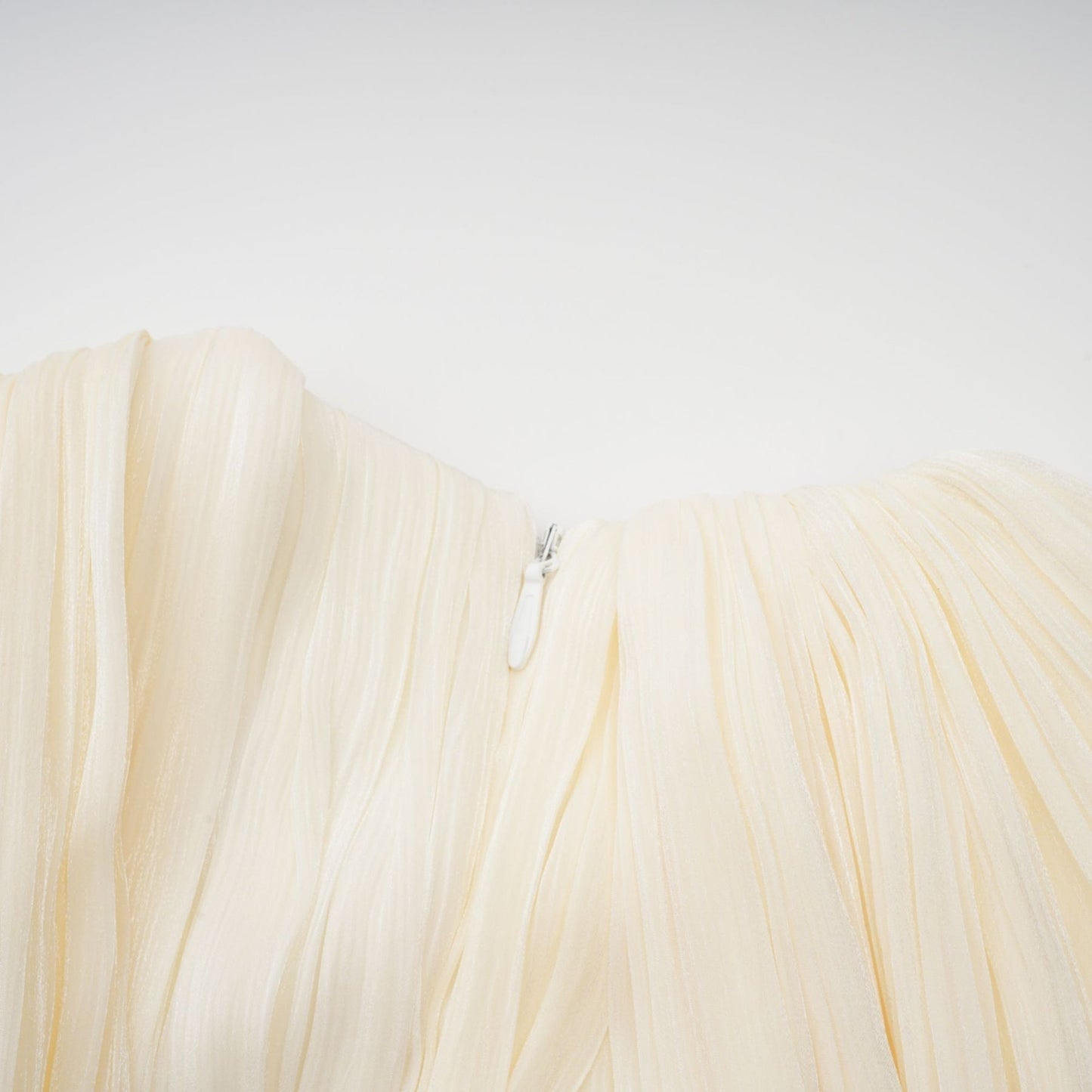 Pleated light colored mini dress with ribbon accent and short sleeves