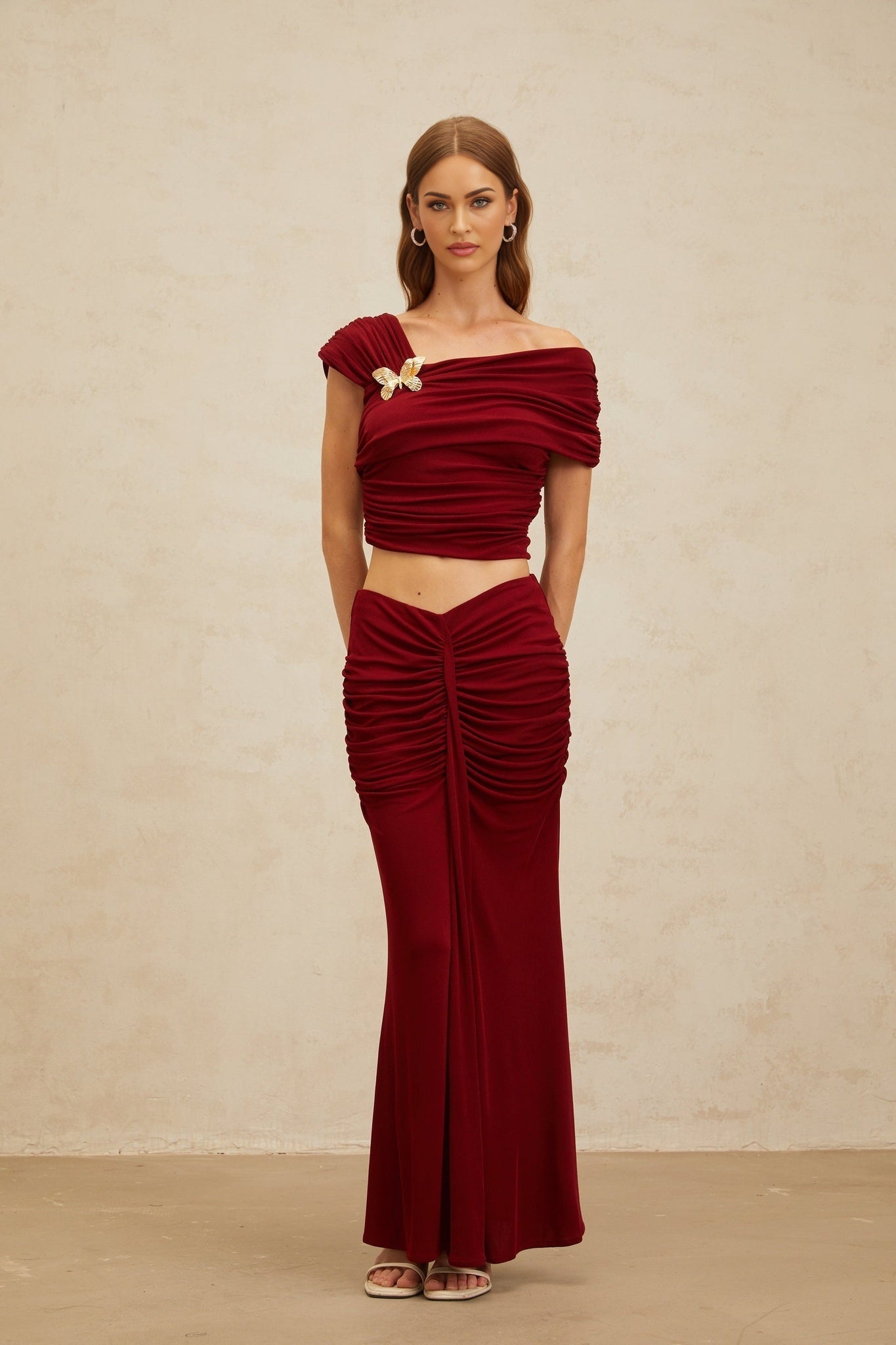 Red Asymmetrical Cap Sleeve Top with Butterfly Brooch and Ruched Detailing, paired with Red Mermaid Hem Maxi Skirt with Front Slit and Rear Zip Fastening