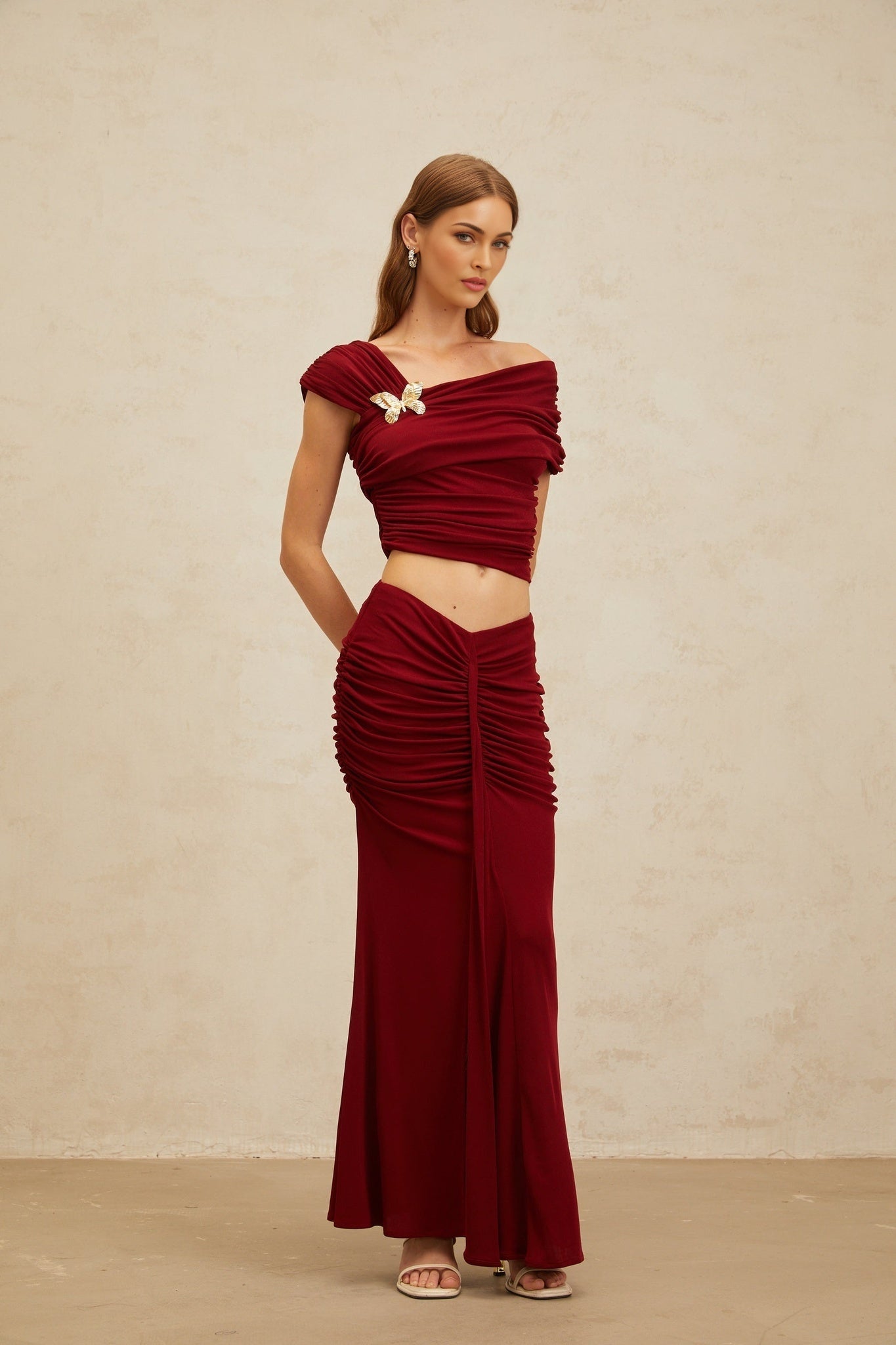 Red asymmetrical design cropped top and mermaid hem maxi skirt with butterfly brooch and ruched detailing