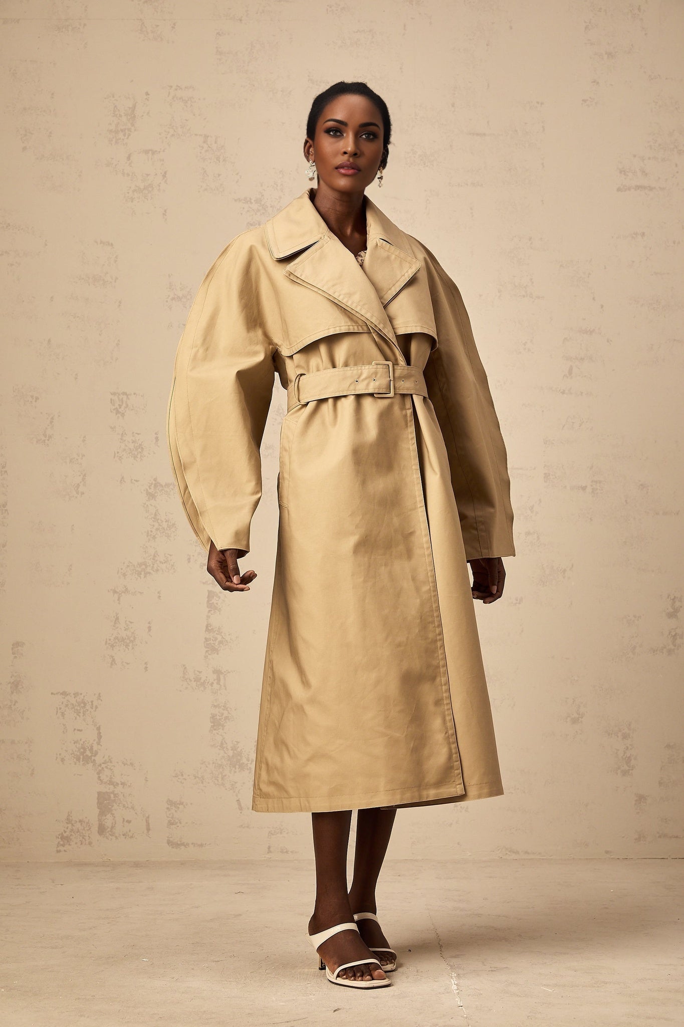 Stylish khaki trench coat with curved sleeves featuring a Jaden design