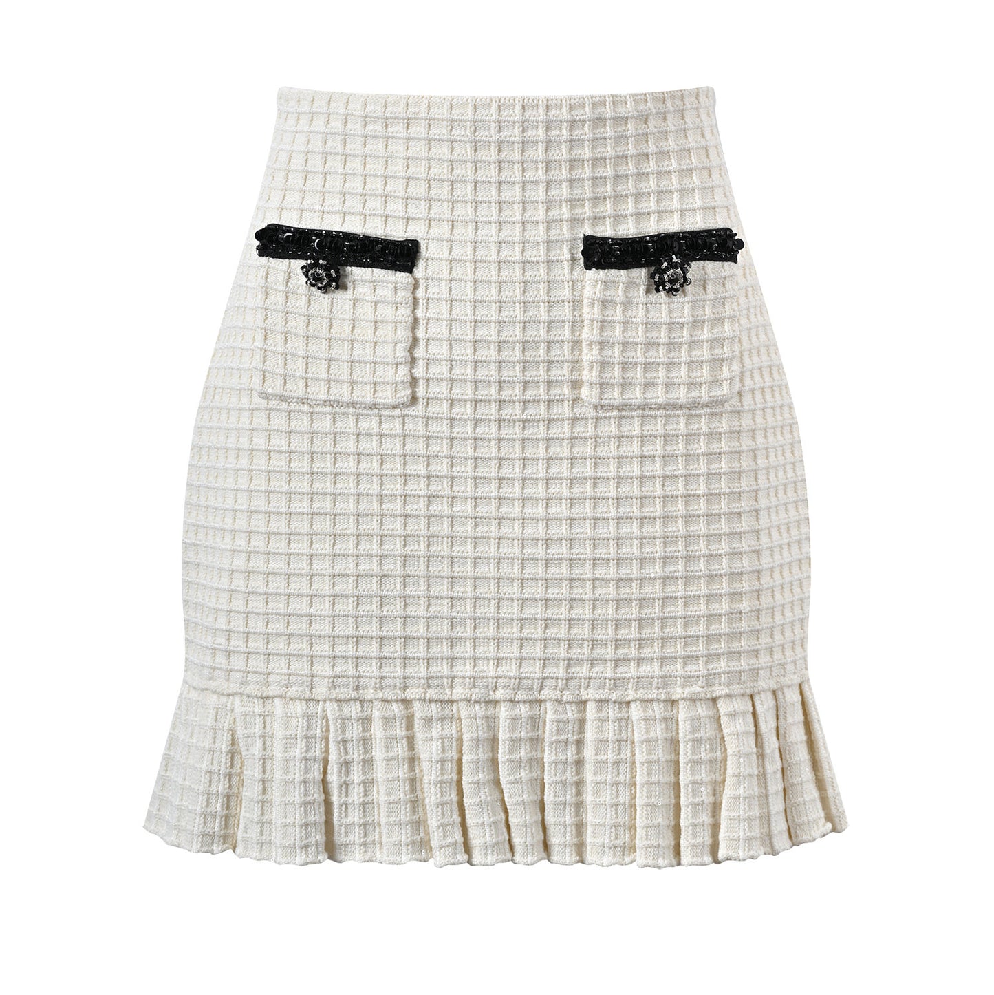 Textured white knitted jacket with black trim and decorative buttons paired with a ruffled hem skirt