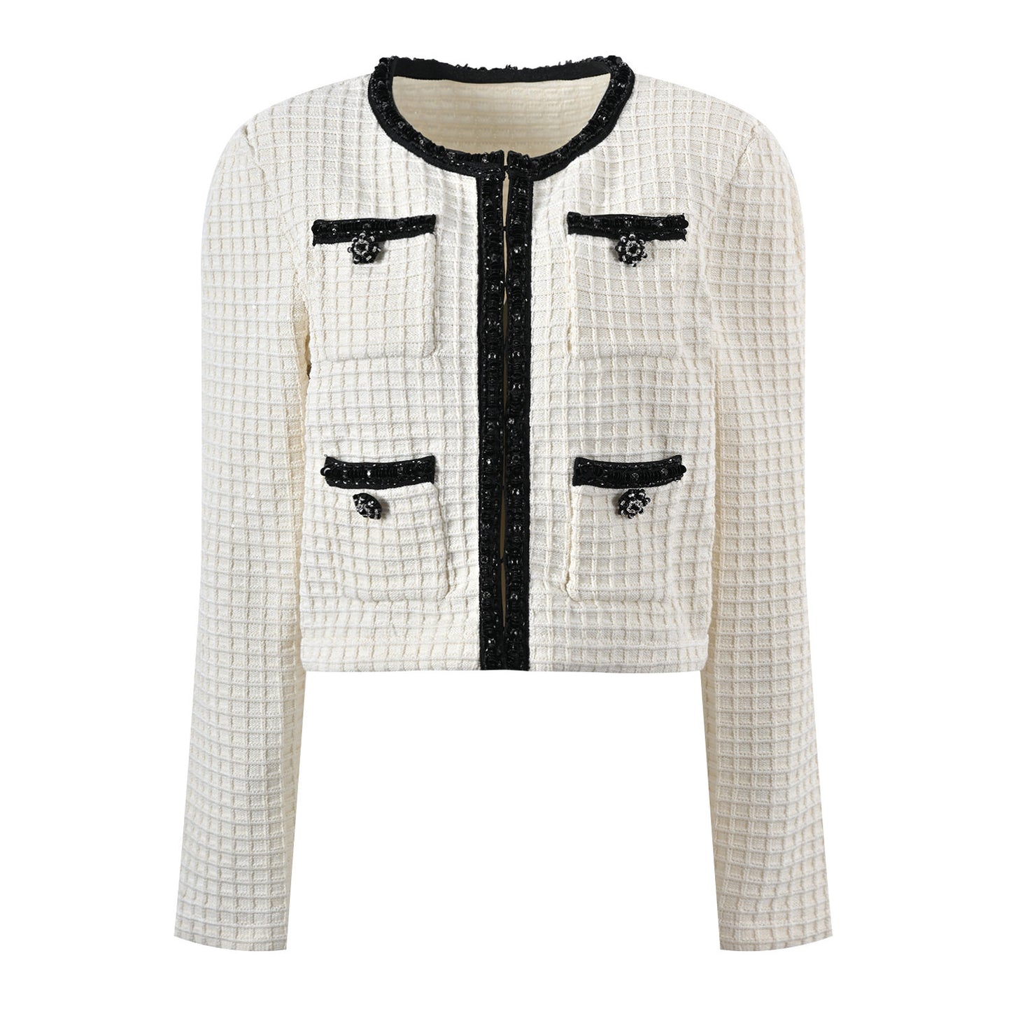 Textured white knitted jacket with black trim and decorative buttons paired with a ruffled hem skirt