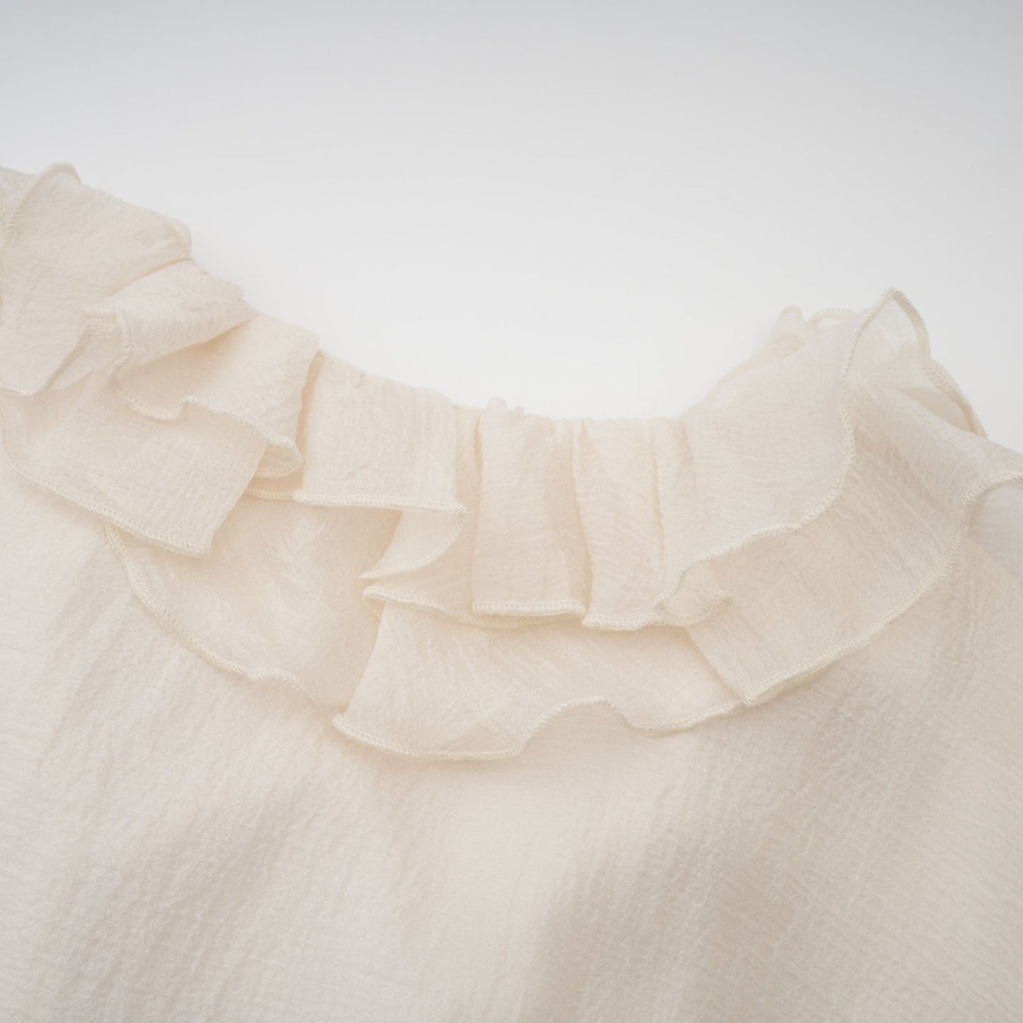 Tiered mini dress in neutral tones with floral applique detailing named Zephyrine