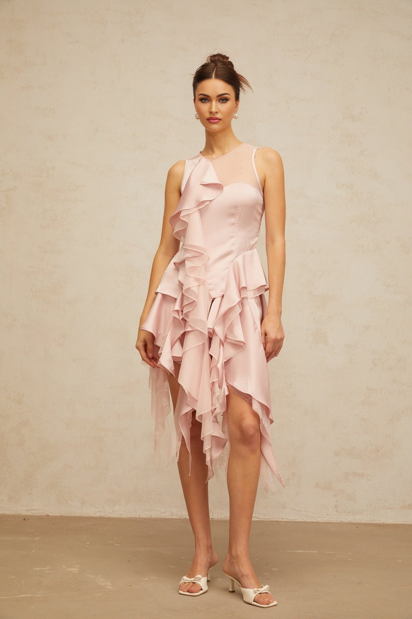 Two piece pink outfit with asymmetrical top and matching skirt featuring ruffles and paneled design