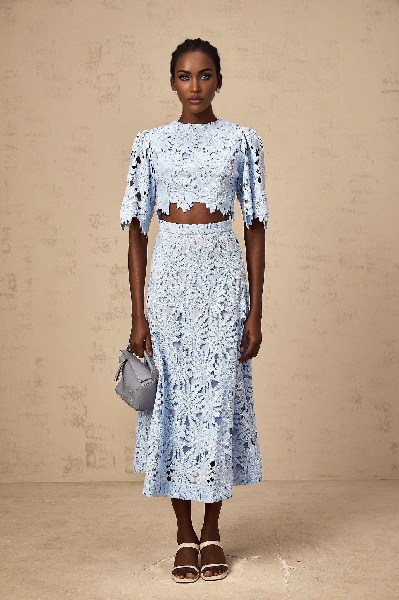 Two piece womens outfit featuring a blue guipure lace top and matching skirt in Audrey style