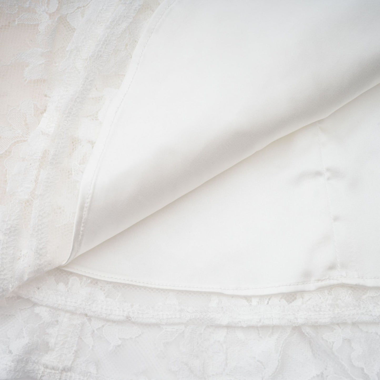 Vivienne white mini dress with floral lace design and corset style bodice on a plain background