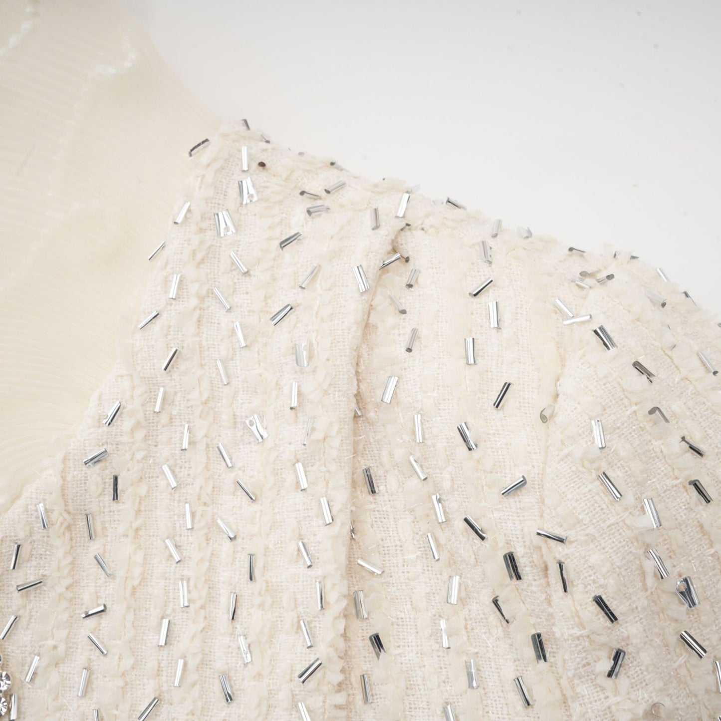 White cropped jacket with beaded details and ruffle trim