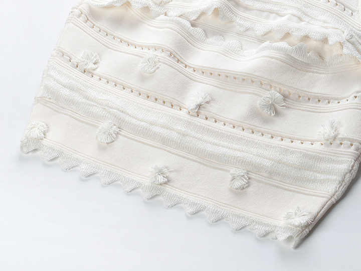White embroidered crop top and high-waisted skirt with scalloped edges and boho-chic vibe