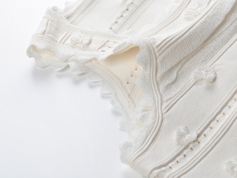 White embroidered crop top and high-waisted skirt with scalloped edges and eyelet accents