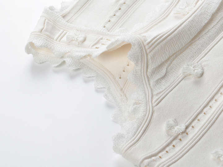 White embroidered crop top and high-waisted skirt with scalloped edges and eyelet accents
