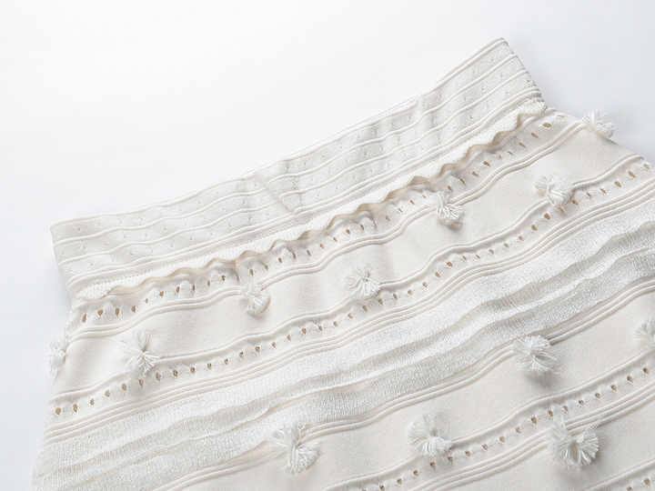 White embroidered sleeveless top and high-waisted skirt