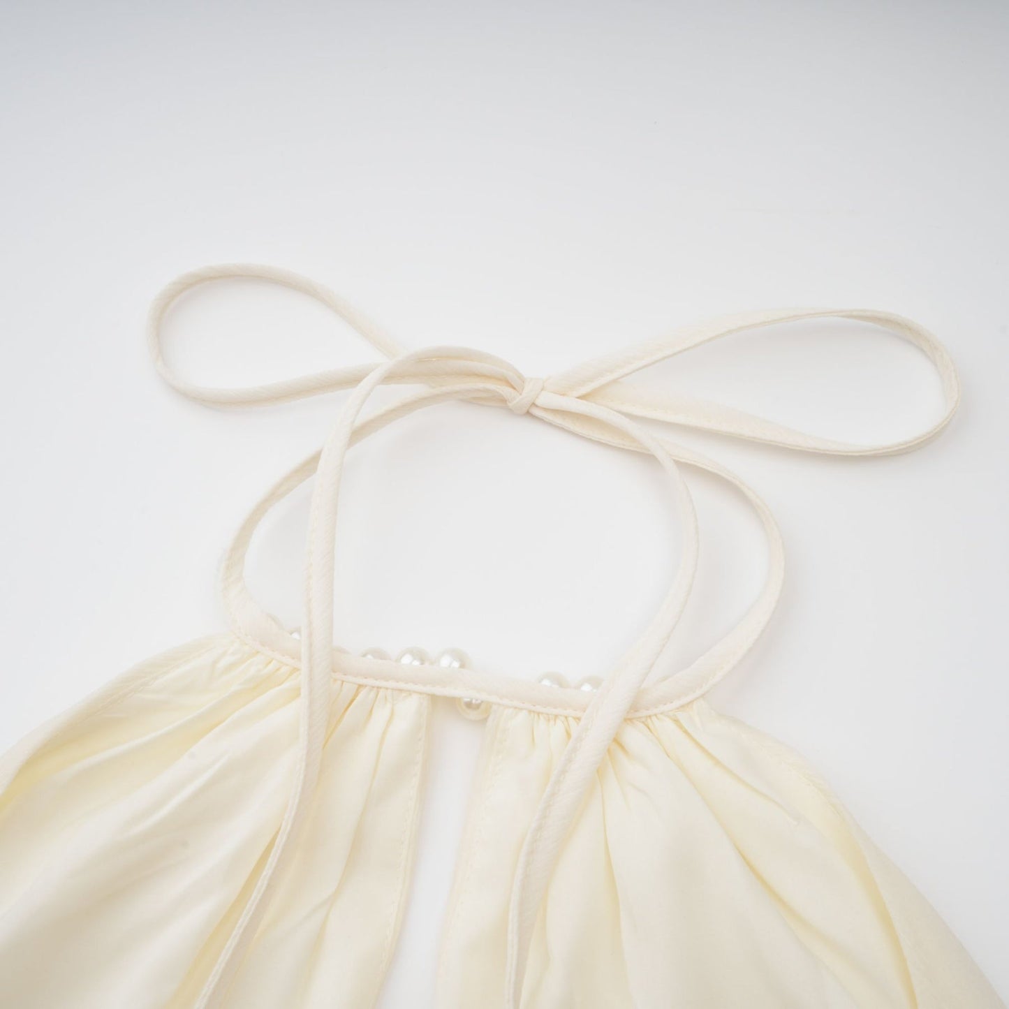 White halterneck mini dress with faux pearl embellishments called Berenice