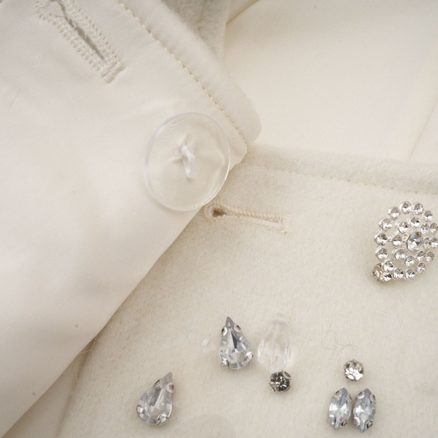 White jacket with cape design featuring embellishments and delicate beadwork