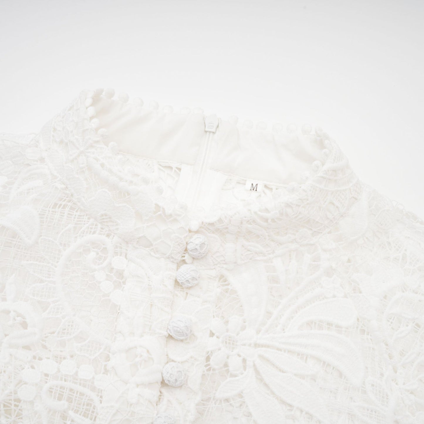 White Aline dress with crew neck long sleeves embroidered lace detail cinch waist and a flounce hem Front button fastening with a cutout design and composed of 70% Cotton 20% Terylene 10% Viscose