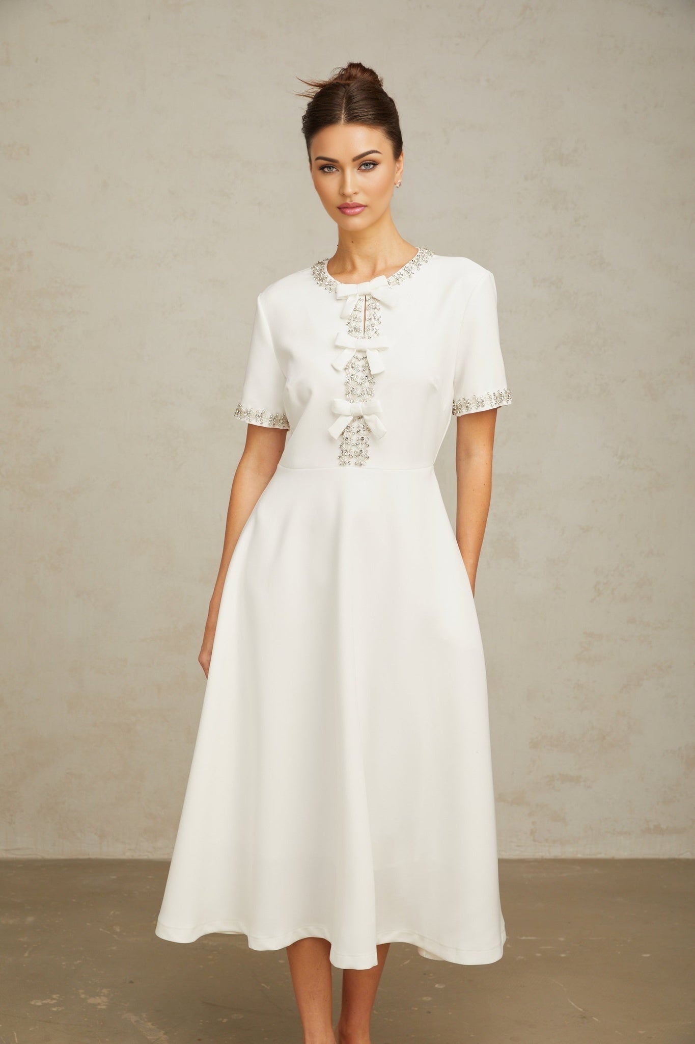 White midi dress with crystal accents and bow detail named Cassiopeia