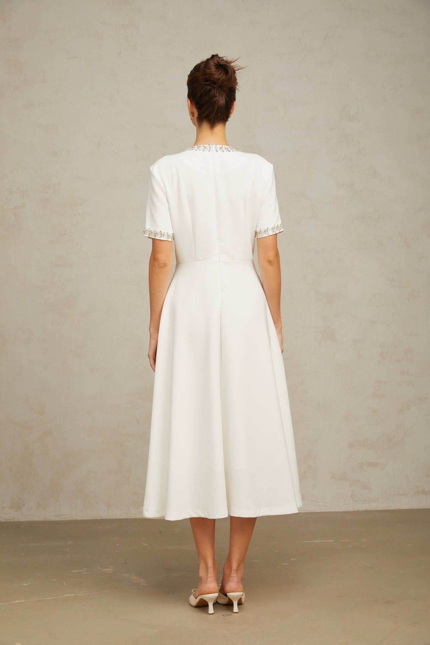 White midi dress with crystal accents and bow detail named Cassiopeia