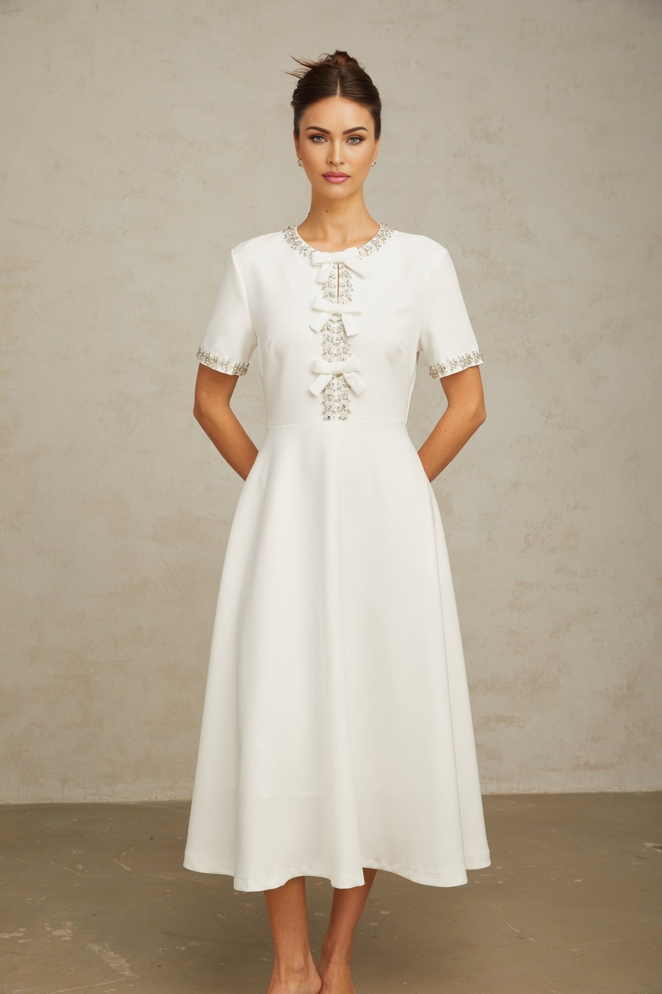 White midi dress with crystalaccented bow and Cassiopeia inspired design