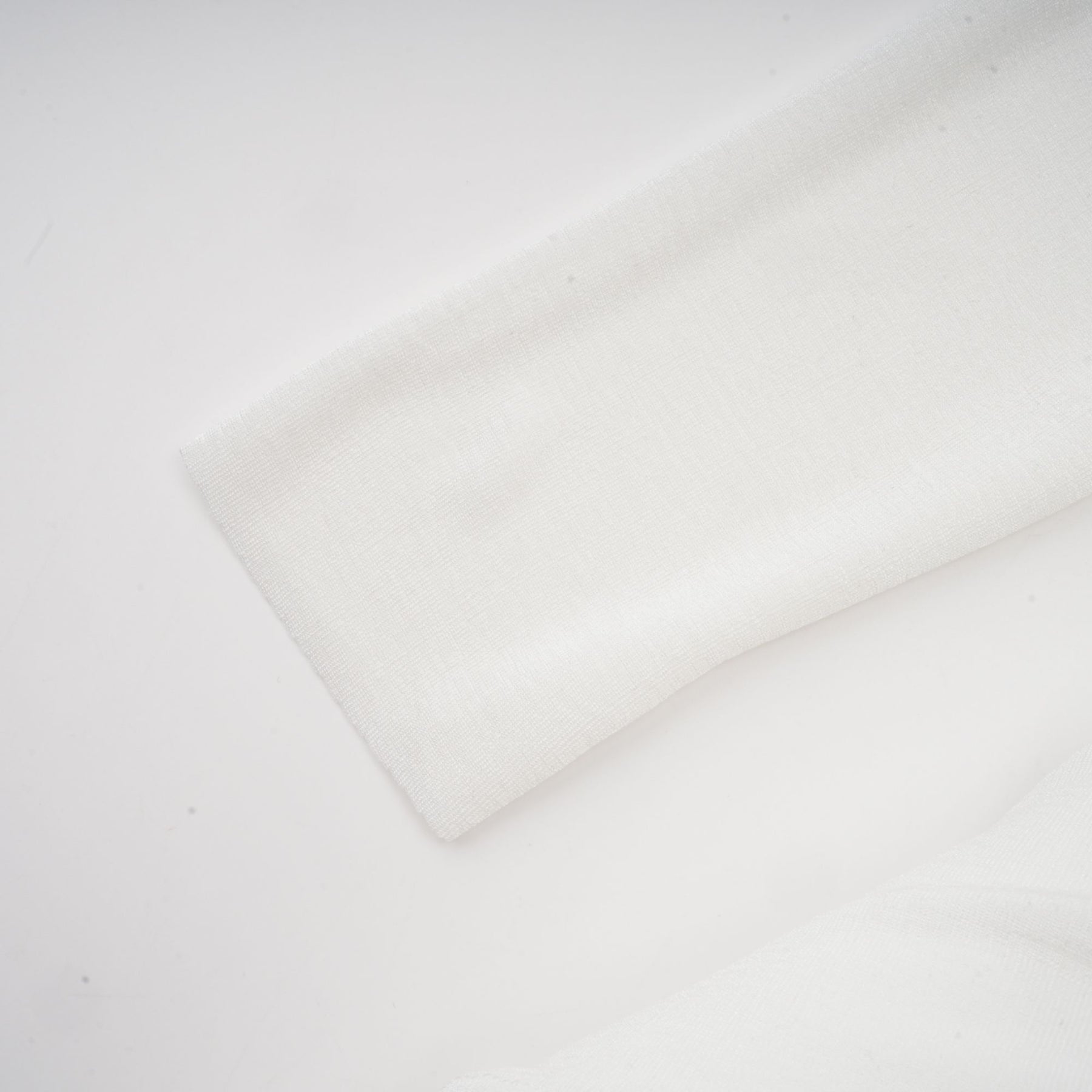 White offshoulder maxi dress with panels worn by model standing against plain background