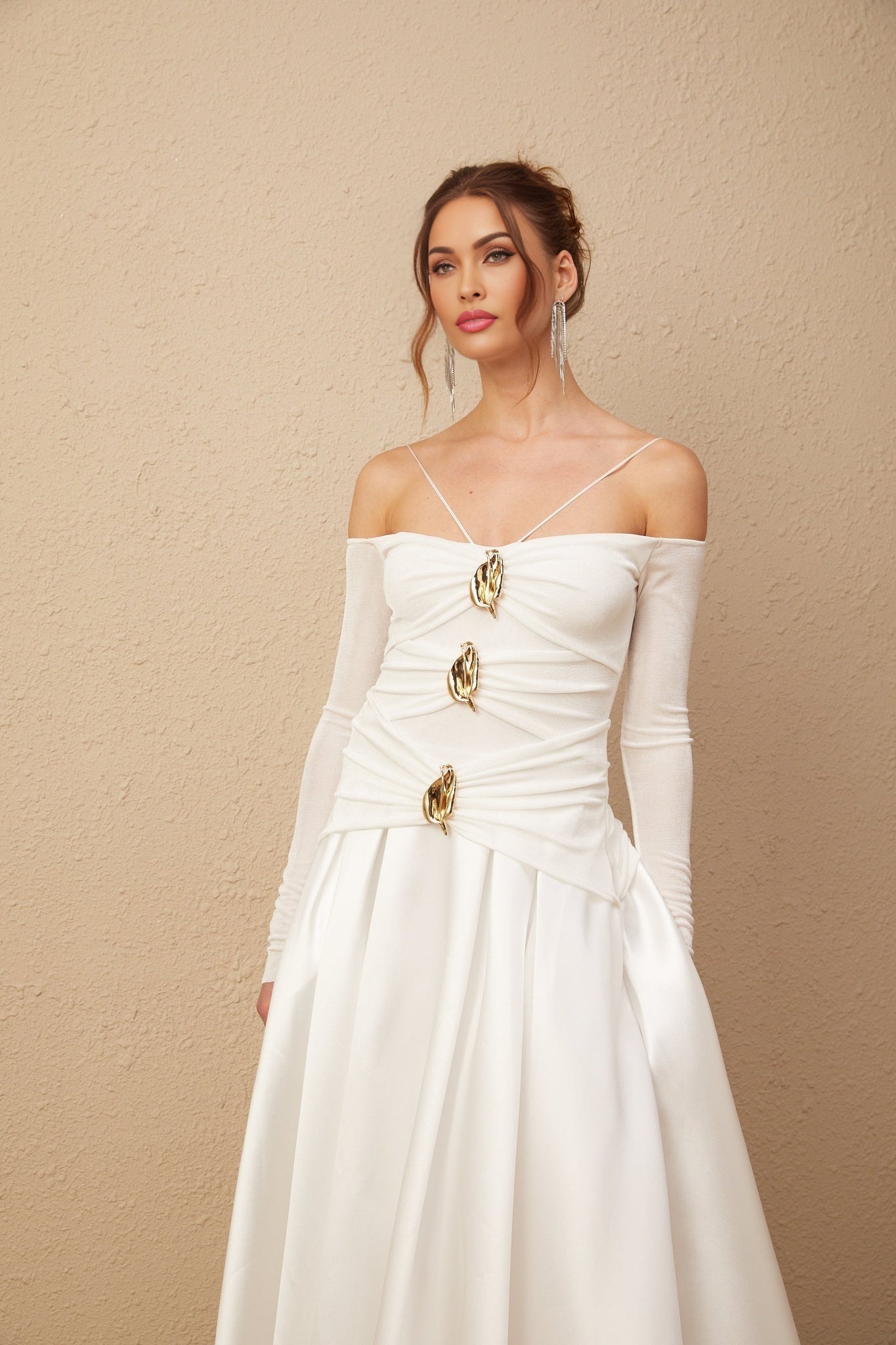 White offshoulder maxi dress with panels worn by model standing against plain background