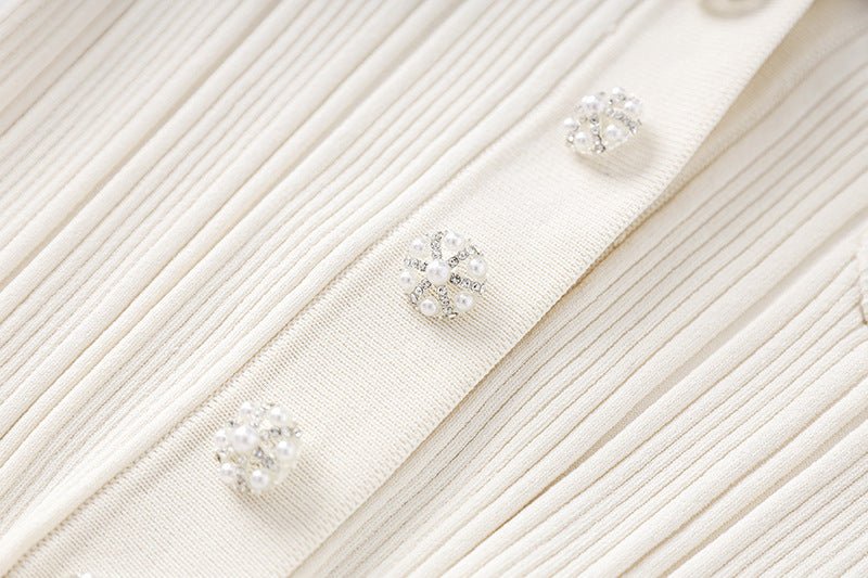 White ribbed knit button-down with flared hemline and decorative buttons