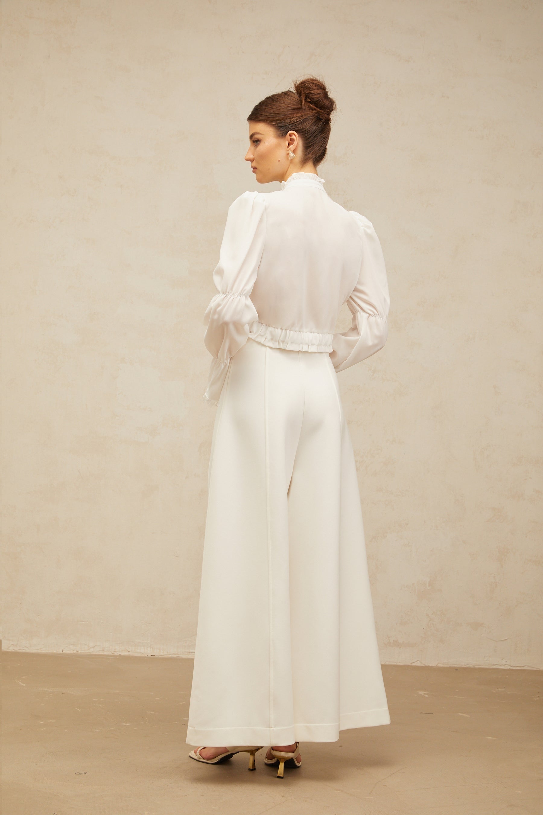 White ruffled shirt with shirred panel and bow detail at neckline