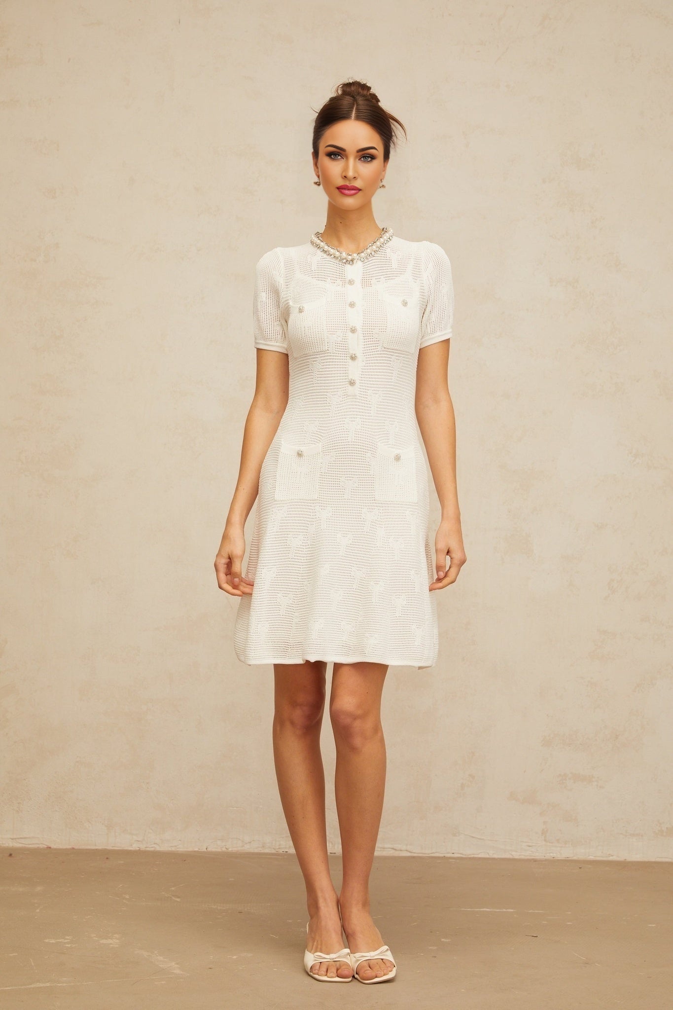 White sleeveless mini dress with embellished crochet knit pattern and scalloped hem