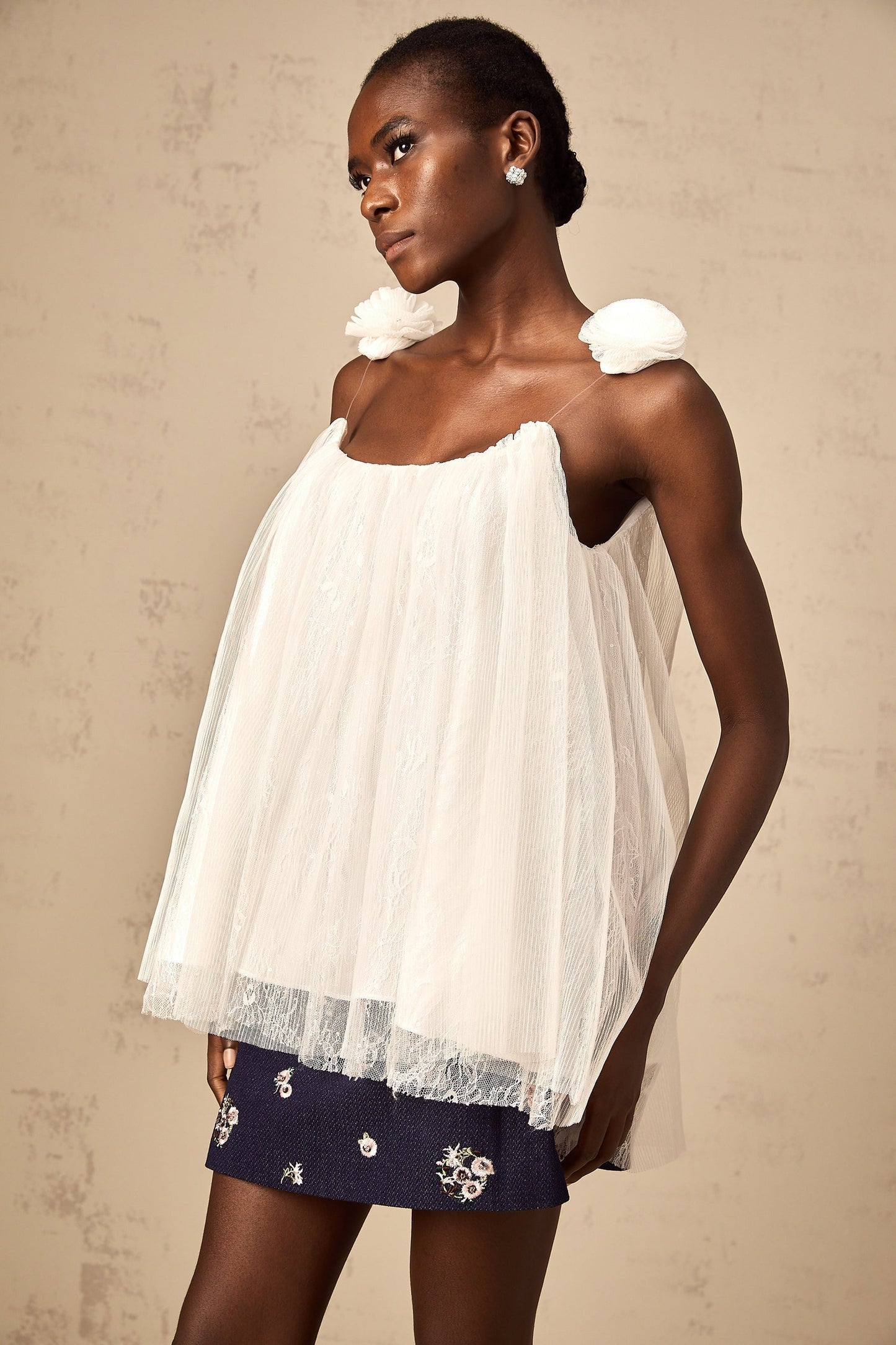White sleeveless top with floral mesh overlay and flower appliques