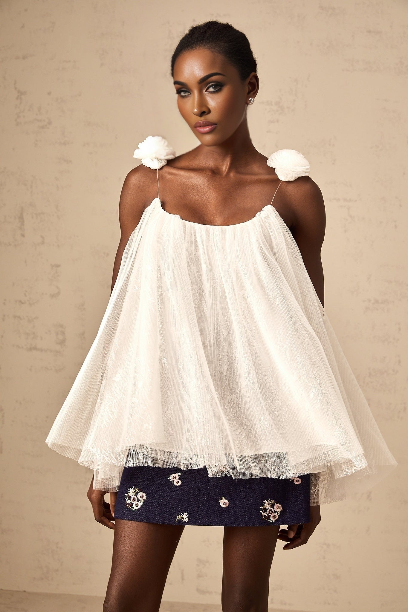 White sleeveless top with floral mesh overlay and flower appliques