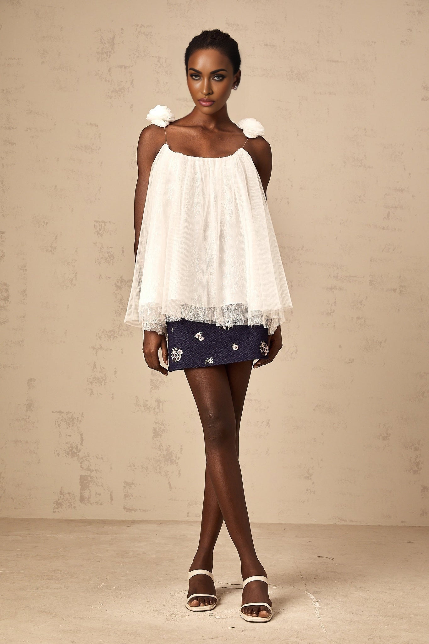 White sleeveless top with floral mesh overlay and flower appliques