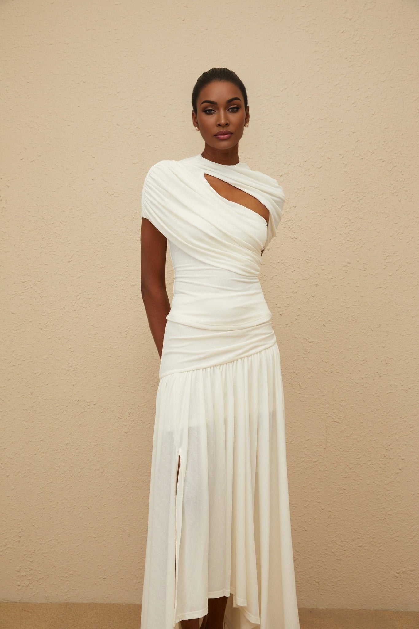 White stretch design asymmetrical top with ruched detailing and fitted silhouette, paired with high rise skirt with shirred panel and side slit