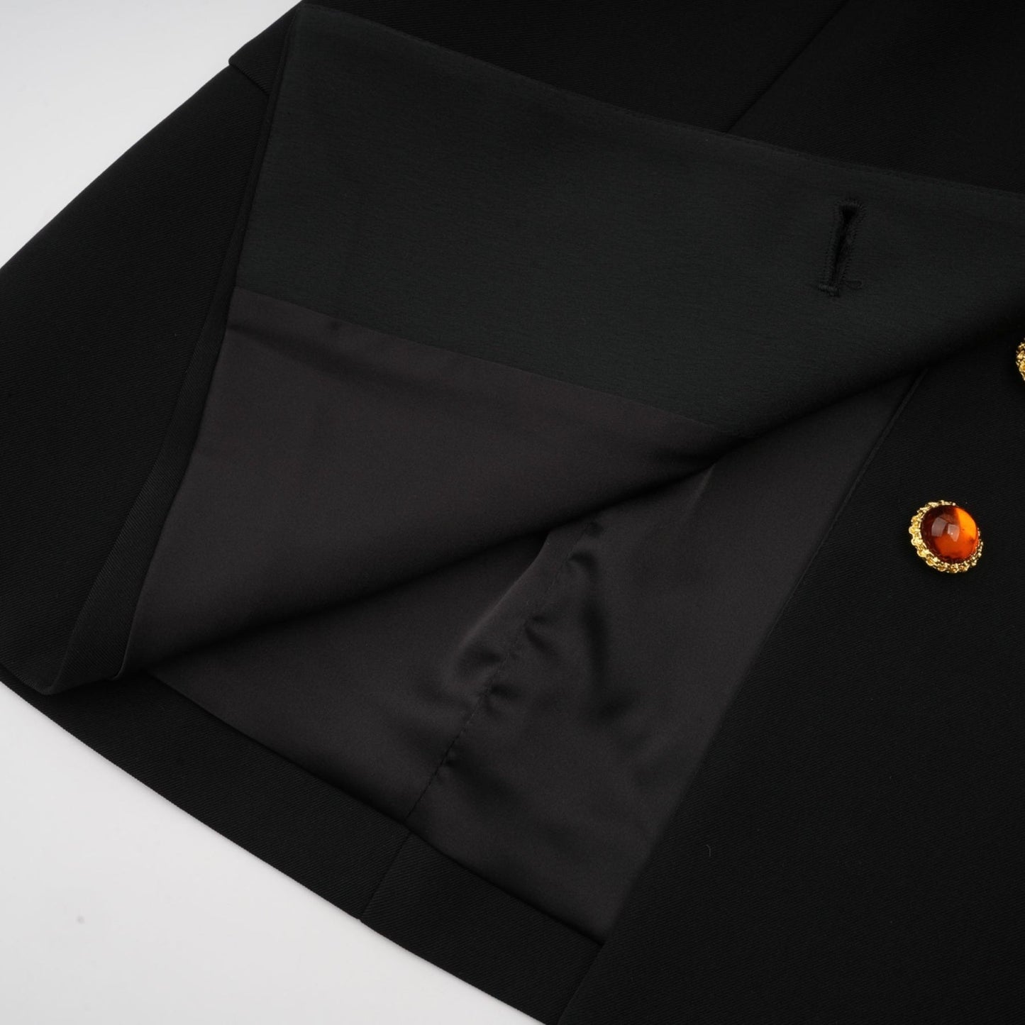 Woman wearing a black blazer dress with single button closure and slim fit silhouette